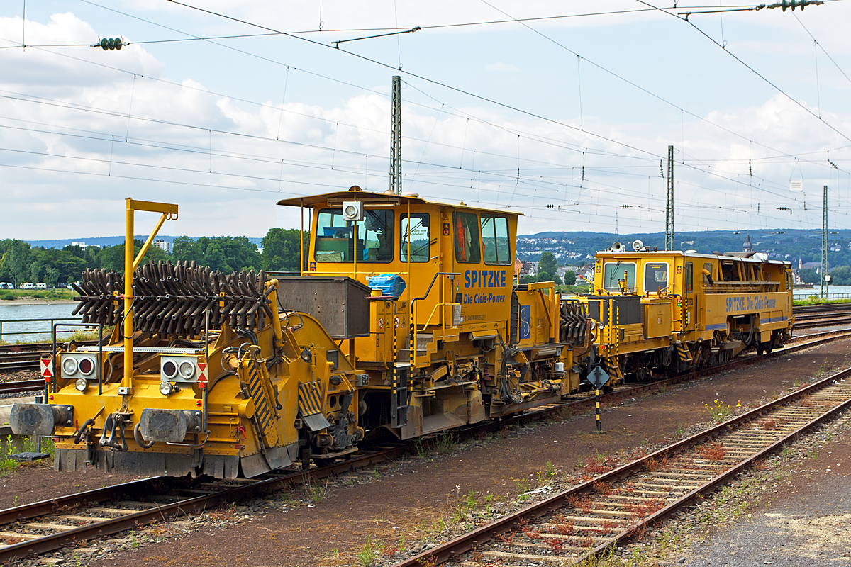 
Deutsche Plasser Schnellschotterplaniermaschine SSP 110 SW (Schweres Nebenfahrzeug Nr. D-SPAG 99 80 9425 020-1) sowie dahinter Plasser und Theurer Zweischwellenstopfmaschine (Nivellier-, Hebe-, Richt- und Stopfmaschinen) 09-32 CSM (Schweres Nebenfahrzeug Nr. D-SPAG 99 80 9222 001-6) der Spitzke SE (Großbeeren) abgestellt am 14.06.2014 in Koblenz-Ehrenbreitstein.

Die Schotterverteil- und Planiermaschinen SSP 110 SW stellen den erforderlichen Regelbettungsquerschnitt in Gleisen und Weichen her. Die Maschinen verfüllen, planieren und kehren das Gleis. Sie verfügen über Besenwellen für alle Oberbauformen und ein Silo zur Aufnahme von Schotter.
Der Schotterpflug SSP 110 SW wurde 1993 unter der Fabriknummer 484 bei der Deutsche Plasser gebaut.

Die Zweischwellenstopfmaschinen 09-32 CSM sind kontinuierlich arbeitende Stopf,- Hebe- und Richtmaschinen. Der kontinuierliche Arbeitsablauf ermöglicht sehr hohe Schichtleistungen. 
Das Stopfen im Bereich von Weichen ist mit ihr nicht möglich.
Die Maschine wurde 1995 unter der Fabriknummer 2722 von Plasser und Theurer gebaut.