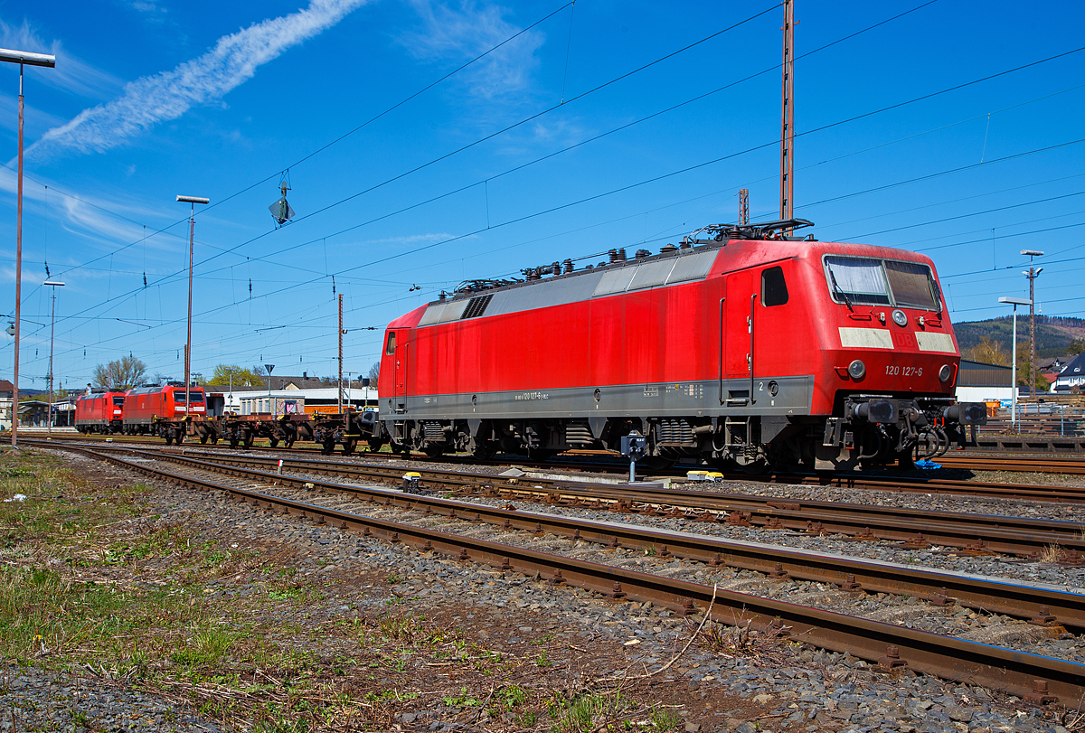 Die 120 127-6 (91 80 6120 127-6 D-BLC) der Bahnlogistik24 GmbH (Dresden) ist am 17.04.2022 in Kreuztal angestellt. Eigentümer der Lok ist die Nürnberger Leasing GmbH (Schwaig).

Die Lok wurde 1987 von Krauss-Maffei in München-Allach unter der Fabriknummer 19958 (die elektrische Ausrüstung ist von Siemens) gebaut DB geliefert. Bis 2021 war sie im Bestand der DB Fernverkehr AG, nun fährt sie für die Bahnlogistik24 GmbH (BLC), wobei Eigentümer der Lok ist die Nürnberger Leasing GmbH (Schwaig).

Eigentlich beträgt die Höchstgeschwindigkeit dieser Baureihe 200 km/h (als BR 120.2 160 km/h), bei dieser konnte ich sehen das sie nur für 140 km/h noch zugelassen ist.

Die Baureihe 120 ist eine Elektro-Lokomotivbaureihe der Deutschen Bahn AG. Sie gilt als die weltweit erste in Serie gebaute Drehstrom-Lokomotive im Hochleistungsbereich mit Umrichter in Halbleitertechnik und ist ein Meilenstein in der Entwicklung elektrischer Lokomotiven. Sie repräsentierte zu ihrer Zeit den letzten Stand der Entwicklung des Drehstromantriebs, bei dem aus dem Wechselstrom der Fahrleitung in Traktionsstromrichtern der Drehstrom zum Antrieb der Asynchron-Fahrmotoren gewonnen wird. Ausgehend von der Technologie der Baureihe 120 wurden Mitte der 1980er Jahre die ersten ICE-Triebköpfe entwickelt. Bis 2020 wurden fast alle sich noch im Einsatz befindlichen Loks der Baureihe 120 abgestellt, wie dies bereits 2019.

Die Serienlok BR 120.1:
Nach vierjähriger Erprobung wurden 1984 insgesamt 60 Serienlokomotiven der Baureihe 120.1 zu einem Stückpreis von 5,5 Millionen D-Mark bestellt.

Die technischen Änderungen im Vergleich zu den Prototypen waren gering, so entfiel beispielsweise die als Rückfallebene eingebaute elektrische Widerstandsbremse, da sich die Nutzbremse entgegen ersten Erwartungen als zuverlässig herausgestellt hatte. Dafür erhielten die Lokomotiven einen zusätzlichen Hochspannungsfilter, der zwei zusätzliche Dachleitungen erforderlich machte. Diese wurden bei den Vorserienlokomotiven nachgerüstet. Kritisch betrachtet, wurden die mechanischen Schwächen der Vorserienmodelle der Baureihe 120.0 ebenfalls in der Serie beibehalten. Nach erfolgreichen Versuchen mit den für maximal 160 km/h zugelassenen Prototypen 120 001 bis 004 und der bereits für 200 km/h zugelassenen 120 005 konnten die Serienloks für bis zu 200 km/h zugelassen werden.

Am 13. Januar 1987 übergab die Industrie im Bundesbahn-Ausbesserungswerk München-Freimann mit der 120 103 die erste Serien-Drehstromlokomotive an die damalige Deutsche Bundesbahn. Die Auslieferung der Serienloks dauerte bis Ende des Jahres 1989. Sie wurden sofort im planmäßigen Dienst eingesetzt, wobei sie in einem gestrafften Umlaufplan tagsüber Intercity- und Interregio-Züge und nachts schnelle Güterzüge bespannten.

Ausmusterung:
Durch den technischen Fortschritt im Bereich der Schienenfahrzeugtechnik gilt die Baureihe 120 mittlerweile als überholt und zeigt sich zunehmend störanfällig. Der Betriebsbestand der Serienmaschinen bei der DB ist stetig rückläufig. Erste Serienlokomotiven sind bereits verschrottet. Andere Lokomotiven wurden verkauft, wie auch diese hier.

TECHNISCHE DATEN:
Spurweite: 1.435 mm,
Achsformel: Bo`Bo`
Länge über Puffer: 19.200 mm
Drehzapfenabstand: 10.200 mm
Achsabstand im Drehgestell: 2.800 mm
Treibraddurchmesser: 1.250 mm (neu)
Dienstgewicht: 83,2 t
Anzahl der Fahrmotoren: 4
Dauerleistung: 5.600 kW (4 x 1.400 kW)
Anfahrzugkraft: 340 kN (20 137 bis 120 160 nur 290 kN)
Höchstgeschwindigkeit: 200 km/h (als BR 120.2 160 km/h)
Fahrmotoren: 4 Drehstrom-Asynchron-Motoren
Antrieb: Hohlwellen-Kardan-Einzelachsantrieb 