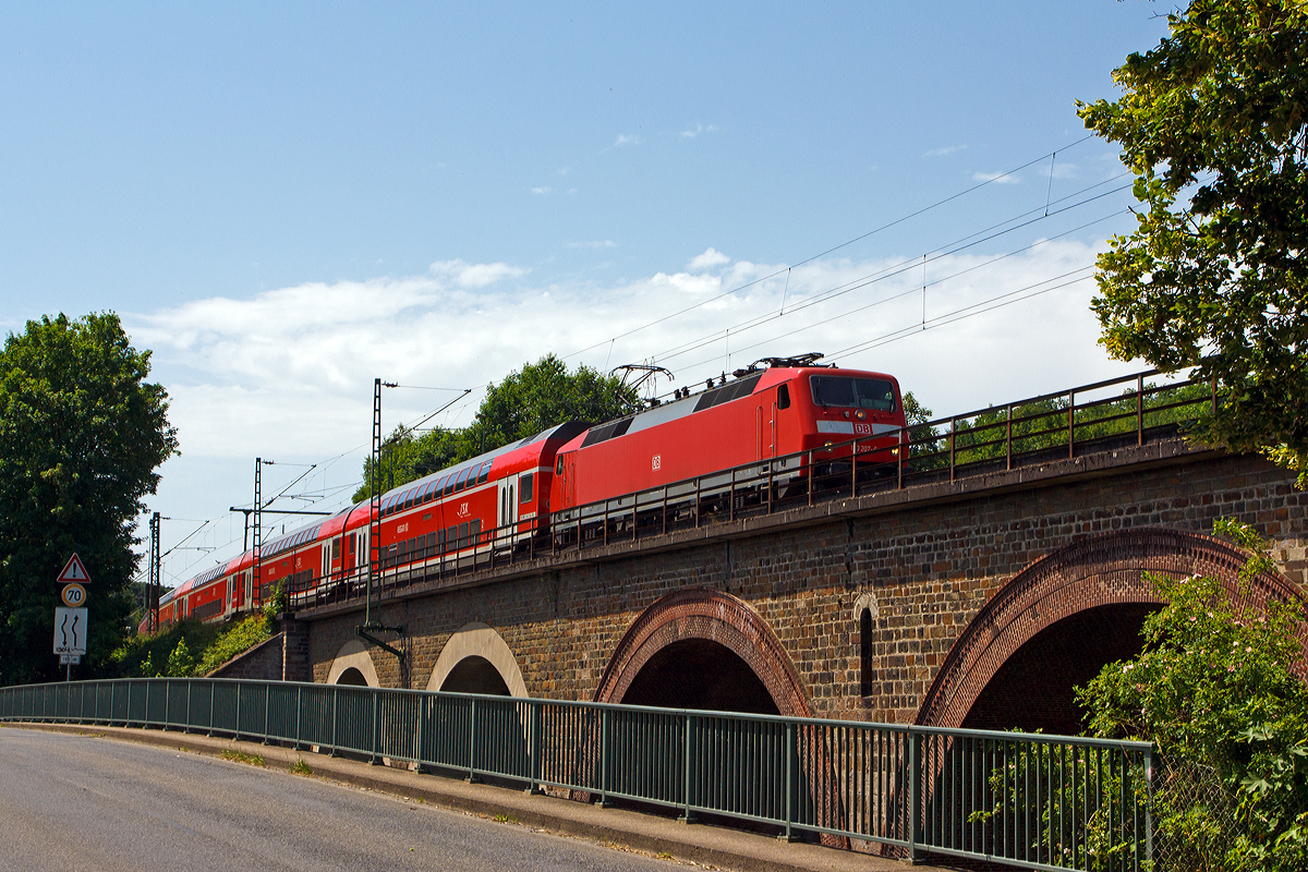 
Die 120 207-6 (ex 120 136-7) der DB Regio mit 6 DoSto´s als RE 9 - Rhein Sieg Express (RSX) Aachen - Köln - Siegen überquert am 10.06.2014 bei Au(Sieg) die Sieg und fährt in Richtung Siegen.

Die Lok wurde 1988 von Krauss-Maffei unter der Fabriknummer 19961 (die elektrische Ausrüstung ist von Siemens) gebaut und als 120 136-7 an die DB geliefert, ende 2010 wurde sie mit einem Nahverkehrspaket ausgestattet (Zugzielanzeiger, Zugabfertigungssystem, Server u. a.) und in 120 207-6 umgezeichnet. 

Wegen der erhöhten fahrdynamischen Werte bildet sie mit sechs neuen Doppelstockwagen einen Wendezug (anstelle von fünf). Sie hat die NVR-Nummer 91 80 6120 207-6 D-DB.