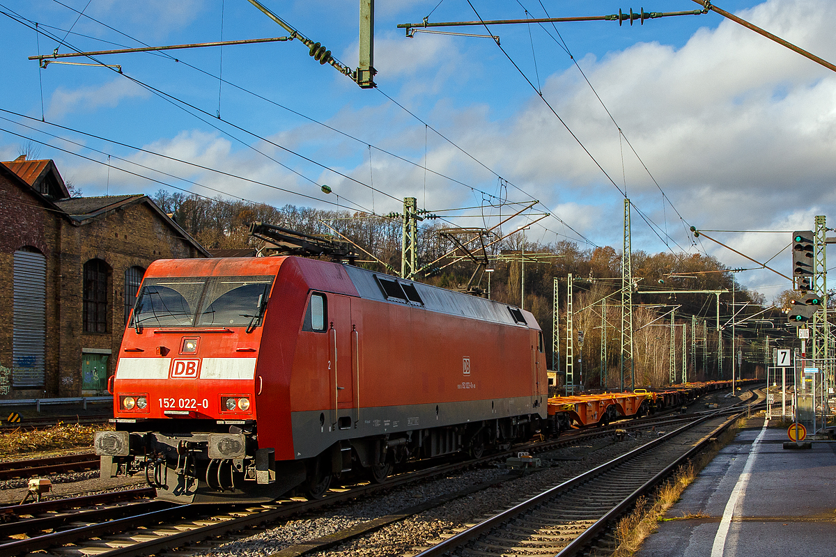 Die 152 022-0 (91 80 6152 022-0 D-DB) der DB Cargo AG fährt am 16.12.2020 mit einen Leerzug von Containertragwagen (u.a. der Gattung Sgns, Sggrs und Sggmrs), durch den Bahnhof (Sieg) in Richtung Siegen.

Die Siemens ES64F wurde1998 noch von Krauss-Maffei unter der Fabriknummer 20149 für die Deutsche Bahn AG gebaut.

Die DB Baureihe 152 (Siemens ES64F):
Für den Güterverkehr benötigte die Deutsche Bahn Mitte der 1990er-Jahre dringend neue leistungsstarke Lokomotiven. Als Teil des  großen Beschaffungsprogramms für Triebfahrzeuge  der Deutschen Bahn AG wurde nach einer im Jahr 1993 erfolgten Ausschreibung über drei Lokomotivbaureihen 1995 ein Vertrag zwischen DB AG und Krauss-Maffei Verkehrstechnik GmbH (mit dem Partner Siemens) über die Lieferung von 195 Güterzuglokomotiven der oberen Leistungsklasse der Baureihe 152 geschlossen. Der Vertrag beinhaltet eine Option über 100 weitere Lokomotiven, die in direktem Anschluss an die erste Serie zu liefern wären, d. h. in den Jahren 2001 bis 2003.

Technische Basis des Angebots und des Vertrags war die gemeinsam von Krauss-Maffei und Siemens entwickelte EuroSprinter-Familie. Aufgrund des modularen Konzepts der EuroSprinter-Familie und der positiven Betriebserfahrungen in Spanien, Portugal und in Deutschland konnten die technischen Verhandlungen, ausgehend vom funktionalen Lastenheft der DB AG, sehr zielstrebig und effizient geführt werden.

Bei Bau und Entwicklung der neuen Lokomotiven wurde auf neueste Erkenntnisse der Technik Rücksicht genommen. Der Führerstand verfügt über eine Klimaanlage und sogar ein Getränke-Kühlfach für den Lokomotivführer. Zur besseren Sicht bei Dunkelheit wurden, wie auch bei der Baureihe 101, Fernscheinwerfer eingebaut. Interessant sind bei diesen Lokomotiven auch die außen liegenden Scheibenbremsen. Zum Schutz der Umwelt wurden umweltverträgliche Kühlmittel und Lacke auf Wasserbasis verwendet. Die Baureihe 152 hat sich seitdem sehr gut bewährt und läuft, im Gegensatz zur 101, auch weitgehend störungsfrei.

Die ersten vier Lokomotiven wurden bereits 1997 in Betrieb genommen und mit Zulassung des Eisenbahn-Bundesamtes (EBA) geliefert. Ab 1998 lief die Serienlieferung planmäßig. Die ersten zehn Lokomotiven wurden seit dem Fahrplanwechsel im Mai 1998 in einem zehntägigen Umlauf Padborg - Basel eingebunden. Sie zeigten bisher keine Auffälligkeiten und arbeiten zur Zufriedenheit des Betriebes.

Die Abnahmefahrten erbrachten die Bestätigung, dass die im Lastenheft geforderte Leistungsfähigkeit in den vollen Umfang realisiert wurde. Anlässlich einer Vorführfahrt in Österreich wurde die Leistung sogar auf 7 MW gesteigert. Teilweise wurden schwere Güterzüge mit nur drei Motoren gefahren und in keinem der Fälle wurden die thermischen Grenzwerte der Bauteile erreicht. Bei einer Vorführfahrt durch die Schweiz nach Italien wurde ein 3.200-t-Tonerde-Zug mit über 640 kN Anfahrzugkraft in Doppeltraktion ruckfrei angefahren. Damit konnten die bei der Leistungsauslegung eingebauten Reserven wirkungsvoll nachgewiesen werden.

Die BR 152 ging in den Lokomotivbestand von der DB Cargo AG (zeitweise unter Railion bzw. DB Schenker Rail firmiert) ein und sollte dort in erster Linie die sechsachsigen Lokomotiven der BR 150 bzw. 151 ersetzen. Die Lokomotive kann aber auch im Personenverkehr eingesetzt werden. So ist die BR 152 dank hoher Leistung und Zugkraft z.B. sehr gut für schwere Doppelstockzüge im Wendezugbetrieb geeignet.

Zur Auslieferung aller bestellten 195 Stück der 152er kam es allerdings nicht, da wegen einer geringfügigen Überschreitung der Achslasten bekam die neue Baureihe bei der Österreichischen Bundesbahn (ÖBB) keine Zulassung. Man musste handeln. Die neuen Lokomotiven wurden dringend für den Güterverkehr nach Österreichisch benötigt, für eine weitere Neuentwicklung waren weder Zeit noch Geld vorhanden. So wurde die Bestellung über die letzten 25 Stück der BR152 storniert und in die Zweisystemloks Siemens ES64U2 (baugleich mit ÖBB Reihe 1116 - Zweisystemloks „Taurus“) umgewandelt. Diese Lokomotiven wurden im Jahr 2001 ausgeliefert und sind seitdem als Baureihe 182 bei der DB Cargo AG im Dienst.

Konstruktion:
Die Baureihe basiert auf dem von Siemens konstruierten Prototyp ES64P (127 001). Da jedoch klar war, dass die Maschinen doch ausschließlich im Güterverkehr eingesetzt werden sollten und eine Höchstgeschwindigkeit von 140 km/h als ausreichend angesehen wurde, konnte auf die Verwendung von voll abgefederten Fahrmotoren verzichtet und auf den wesentlich einfacheren und preisgünstigeren Tatzlager-Antrieb zurückgegriffen werden. Dieser gilt durch die Verwendung moderner Drehstrommotoren bei niedrigen Geschwindigkeiten als relativ verschleißarm. Die Kraftübertragung zwischen Wagenkasten und Drehgestellen erfolgt in Maffei-Tradition über kräftig dimensionierte und tief herunterreichende Drehzapfen sowie Flexicoilfedern.

Ansonsten entstand eine moderne Maschine mit Drehstromasynchron-Fahrmotoren und doppelten innenbelüfteten Scheibenbremsen. Eine teilredundante Ausführung von hoch beanspruchten Teilen im Antriebsstrang trägt ganz wesentlich zur hohen Zuverlässigkeit und Verfügbarkeit der Baureihe bei.

Der Haupttransformator ist unterflur zwischen den Drehgestellen angeordnet. Jedes Drehgestell verfügt über eine autarke elektrische Ausrüstung, bestehend aus drei Eingangsgleichrichtern in rückspeisefähiger Vierquadranten-Bauweise, Gleichspannungszwischenkreis und zwei Wechselrichtern (einer je Motor). Dadurch wird erreicht, dass bei Ausfall einer Komponente des Antriebsstrangs nicht das gesamte Drehgestell ausfällt, sondern sich lediglich die verfügbare Zugkraft reduziert. Als Leistungshalbleiter kommen wassergekühlte GTO-Thyristoren zum Einsatz. Die Bremskraft der elektrodynamischen Nutzbremse beträgt 150 kN im Bereich zwischen 10 km/h und 140 km/h.

Die Lokomotiven sind mit Zugsammelschiene für die Energieversorgung von Reisezügen sowie Wendezugsteuerung und Notbremsüberbrückung ausgerüstet, so dass sie auch im schweren Personenzugdienst eingesetzt werden können. Durch die Aufteilung der DB AG und Zuordnung der Loks zum Geschäftsbereich Güterverkehr der DB wurde davon seit Ende der 1990er Jahre kein Gebrauch mehr gemacht.

Der Maschinenraum wird von einem beide Führerstände verbindenden Mittelgang durchzogen. Beidseitig sind an den Außenwänden des Lokkastens die elektrische Ausrüstung, die Druckluft- und Bremsgeräte sowie die umfangreichen Kühleinrichtungen angeordnet. Alle Aggregate sind in Form von separaten, austauschbaren Modulen ausgeführt, die von oben in das Fahrzeug eingebracht werden. Dabei wurde auf möglichst kurze Verbindungen, insbesondere bei den Hauptstromleitungen geachtet. Die Steuerleitungen und die Verrohrung sind in Kanälen unter dem Mittelgang verlegt. Die Steuerungs- und Überwachungsgeräte sind an den beiden Enden des Maschinenraums konzentriert.

Die Führerstandsräume sind klimatisiert, wärme- und schallisoliert und verfügen über ein recht großzügiges Raumangebot. Annehmlichkeiten für den Triebfahrzeugführer sind darüber hinaus ein luftgefederter Sitz und ein Thermofach. Die Lokomotiven sind mit Einheitsführerständen ausgerüstet.

TECHNISCHE DATEN der BR 152 (Siemens ES64F):
Hersteller: Krauss-Maffei bzw. Siemens 
Baujahre: 1996-2001
Gebaute Anzah: 170
Spurweite: 1.435 mm (Normalspur)
Achsformel: Bo´Bo´
Länge über Puffer: 19.580 mm
Drehzapfenabstand: 9.900 mm
Achsstand im Drehgestell: 3.000 mm
Treibraddurchmesser: 1.250 mm (neu) / 1.170 mm (abgenutzt)
Breite: 3.000 mm
Dienstgewicht: 86,7 t
Achslast: 21,75 t
Höchstgeschwindigkeit: 140 km/h
Dauerleistung: 6.400 kW (8.701 PS)
Anfahrzugkraft: 300 kN
Dauerzugkraft: 250 KN
Fahrmotoren: 4 Stück fremdbelüfteten vierpolige Drehstrom-Asynchron-Motoren
Getriebeübersetzung: 3,95:1
Antriebsart: integrierter Tatzlagerantrieb
Stromabnehmer: SSS 87 (Einholm)
Stromsystem: 15 kV, 16 2/3 Hz

Elektrisches Antriebssystem: Wassergekühlte GTO-Stromrichter, 3 netzseitige Eingangsgleichrichter (4QS),
Gleichspannungszwischenkreis, 1 Pulswechselrichter pro Fahrmotor, Einzelachsregelung mit 75% Redundanz-

Steuerungs- und Leittechnik: 2 Zentrale Steuergeräte in SIBAS 32 mit integrierter AFB, ZWG, SIFA und zentraler Diagnose, 1 Farbdisplay und MFA pro Führerstand, LZB 80, Gleit- und Schleuderschutz K-Micro.

Bremsausrüstung: Elektrische Netzbremse, Knorr-Führerbremsventilanlage Typ HSM-MEP, Radscheibenbremse, 4 Federspeicher-Festhaltebremsen
