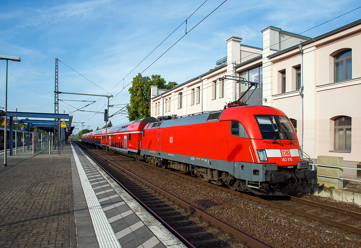 Die 182 015-8  (91 80 6 182 015-8 D-DB) der DB Regio (als Schublok) erreicht am 20.09.2018 mit dem RE 1 den Zielbahnhof Brandenburg an der Havel Hauptbahnhof.  

Die Lok wurde 2001 von Siemens in München-Allach unter der 20312 gebaut. 2011wurde bei Siemens in München-Allach ein Nahverkehrspaket eingebaut.

Die Hersteller-Bezeichnung ES64 ist die Abkürzung von EuroSprinter zusammen mit den ersten beiden Ziffern der Nennleistung (6.400 kW). Die Bezeichnung U steht für Universallok.

Die Lokomotiven der DB AG:
Die österreichischen Behörden verweigerten im Jahr 2001 die Zulassung der DB-Baureihe 152 in Österreich, weil man die auftretenden Gleiskräfte als zu hoch bewertete. Aus diesem Grund wandelte die Deutsche Bahn AG die Bestellung der letzten 25 Lokomotiven der DB-Baureihe 152 in 25 Maschinen der DB-Baureihe 182 um, die der ÖBB-Baureihe 1116 entspricht, allerdings wurde auf den bei der 1116 im Ursprungszustand üblichen dritten Stromabnehmer verzichtet, eine Nachrüstung wäre mit geringem Aufwand möglich.

Bei der Deutschen Bahn wurden die Lokomotiven daher seit der Übergabe der ersten Lokomotive im Juli 2001 wie die Baureihe 152 dem Geschäftsbereich DB Cargo zugeordnet. Damit wurde die Lokomotive mit der größten Höchstgeschwindigkeit (230 km/h) bei der Deutschen Bahn AG in einem Bereich eingesetzt, in dem diese nicht benötigt wird. Als Folge der Finanz- und Wirtschaftskrise gingen im Jahr 2009 die Transportmengen bei Railion (heute wieder DB Cargo) so stark zurück, dass die Güterverkehrssparte der Bahn einen Überhang an Lokomotiven hatte. Zudem hatten weitere Lokomotiven der DB-Baureihe 185 mittlerweile die Zulassung für Österreich erhalten, so dass der ursprüngliche Einsatzzweck auch anderweitig abgedeckt werden konnte. Im Herbst 2009 wurde daher ein Einsatz bei DB Regio in verschiedenen Regionen Deutschlands erwogen und teilweise auch erprobt.

Seit dem Fahrplanwechsel im Dezember 2009 fuhren fünf der Lokomotiven auf der Linie Cottbus–Leipzig. Auch auf der RB-Linie 20 in Thüringen kamen Lokomotiven diese Baureihe von 2010 bis 2015 zum Einsatz. Im Vergleich zu den dort bisher eingesetzten Lokomotiven der DB-Baureihe 143 wurde die Verspätungsanfälligkeit durch Geschwindigkeitsanhebung auf 140 km/h und die wesentlich schnellere Beschleunigung verringert.

Ab 2011 wurden acht Lokomotiven von DB Regio auf der Linie S1 der S-Bahn Dresden eingesetzt werden, um dort ebenfalls die Fahrzeiten zu verkürzen. Aber auch Einsätze als Ersatz für die Baureihe 442 auf dem RE50 Saxonia-Express auf der Relation Dresden – Leipzig waren die Regel. Ab Dezember 2015 wurden die acht Dresdner Lokomotiven (182 016 bis 023) an den Betriebshof Magdeburg-Buckau abgegeben, diese wurden durch die BR 146.0 ersetzt.

Die seit 2015 verkehren Loks der BR 182 mit fünf modernisierten Doppelstockwagen auf der Linie RE1 von Cottbus über Frankfurt (Oder), Berlin, Potsdam und Brandenburg (Havel) bis nach Magdeburg Hbf, entsprechend den Vorgaben des Bestellers (Verkehrsverbund Berlin-Brandenburg). Im August 2016 werden auch die bei DB Regio Südost in Magdeburg nicht mehr benötigten acht Maschinen der Region Nordost übergeben, sodass in diesem Regionalbereich bis auf weiteres alle Maschinen dieser Baureihe eine Heimat finden werden. 

Um sämtliche vorgenannte Talent-2-Ersatzverkehre abdecken zu können, sind im Laufe des Jahres 2011 alle 25 Maschinen der BR 182 in den Bestand der DB Regio übergegangen. Für die Dienste im Personenzugverkehr erhielten die Loks die Zulassung mit ep-Bremse und Notbremsüberbrückung (NBÜ 2004), was zum Erlöschen der Zulassung auf dem Netz der ÖBB-Infrastruktur AG führte – dem ursprünglichen Zweck ihrer Anschaffung. Alle 25 Lokomotiven wurden mit einem Nahverkehrspaket nachgerüstet, welches hauptsächlich aus seitenselektiver Türsteuerung (SAT/TAV) und Fahrgastinformationssystem besteht. 

Als 26. Lok der DB gehört die 182 506 seit 2013 der DB Systemtechnik und wird vor RAILab-Messzügen eingesetzt.

TCHNISCHE DATEN:
Achsfolge:  Bo`Bo`
Spurweite:  1.435 mm
Länge über Puffer:  19.280 mm
Drehzapfenabstand: 9.900 mm
Breite: 3.000 mm
Raddurchmesser (neu):  1.150 mm
Gewicht: 86 t
Spannungssysteme:  15 kV, 16,7 Hz und 25 kV, 50 Hz
Dauerleistung:  6.400 kW
Höchstgeschwindigkeit:  230 km/h
