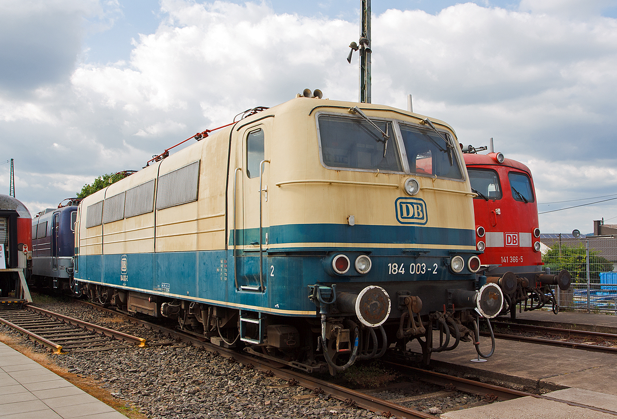 Die 184 003-2, ex DB E 410 003, am 14.06.2014 ausgestellt im DB Museum Koblenz-Lützel. 

Die Mehrsystem-Elektrolokomotive wurde 1966 bei Krupp in Essen unter der Fabriknummer  4837 gebaut, der elektrische Teil ist von AEG. Bei der Deutschen Bundesbahn (DB) wurde sie als E 410 003 in Dienst gestellt.  Mit der Einführung der EDV-Nummer wurde sie zum 01.01.1968 umgezeichnet in DB 184 003-2.  Am 01.04.2002 wurde sie bei der DB AG ausgemustert.

Um einen zeit- und arbeitsintensiven Lokwechsel in den Grenzbahnhöfen zu vermeiden, vergab die Deutsche Bundesbahn 1964 einen Entwicklungsauftrag an AEG, BBC sowie Krupp. Aufgabe war die Entwicklung einer Lokomotive, die den Fahrstrom aus unterschiedlichen Netzsystemen beziehen konnte. Da in den 1960er Jahren der grenzüberschreitende Verkehr nach Frankreich, Belgien und Luxenburg zunahm, entschied man sich bei der Entwicklung für eine vier Systemlokomotive.

Die Baureihe E 410 verfügte über die Ausrüstung zum Betrieb unter mehreren verschiedenen Oberleitungsspannungen. Sie konnte Einsätze unter dem deutschen (15 kV 16,7 Hz) und dem französischen (25 kV 50 Hz) Wechselstromsystem sowie dem belgischen und französischen Gleichstromnetz (3 kV bzw. 1,5 kV) fahren und brachten ihr schnell den Beinamen „Europa-Lok“ ein. Als charakteristisches Merkmal hatte die Baureihe E 410 ursprünglich vier Stromabnehmer. 
Die ersten fahrplanmäßigen Einsätze erfolgten vor Schnellzügen zwischen Köln und dem belgischen Lüttich ab Sommer 1969. Beheimatet waren die 184 im Bw Köln-Deutzerfeld . Die Thyristor-Stromrichter, mit denen die Phasenanschnittssteuerung realisiert wurde, bereiteten im Netz der belgischen Staatseisenbahnen trotzdem Probleme.  Außerdem kam es zu häufigen Lokausfällen aufgrund plötzlich auftretender starker Spannungsschwankungen im belgischen Gleichstromnetz. Der Einsatz im belgischen Netz wurde daher zum 26. September 1971 beendet. Daraufhin kamen die Loks aber im Nahverkehr rund um Köln zum Einsatz, teilweise mit D-Zügen sogar bis nach Rheine. Weil die Lokomotiven so aber nicht wirtschaftlich eingesetzt waren, zog die Bundesbahn 1979 die Maschinen nach Saarbrücken ab und legte die Systeme für Gleichstrombetrieb, einschließlich der betreffenden Stromabnehmer, still.

Aus dieser Baureihe wurden später auch die vier Zweisystemlokomotiven der Baureihe E 310 (ab 1968: Baureihe 181.0) abgeleitet.

Aus der Achsfolge Bo'Bo' geht hervor, dass die Lokomotiven zwei Drehgestelle mit insgesamt vier Fahrmotoren und damit vier angetriebenen Achsen besitzt. Die Kraftübertragung erfolgt mittels Gummiring-Kardanantrieb. Erstmals wurden Drehgestelle mit Lemniskatenanlenkung für besseren Kurvenlauf angewendet. Da die Baureihe 184 sowohl mit Wechsel- als auch mit Gleichstrom betrieben werden sollte, wurden Mischstrommotoren benötigt. Die Lösung fand man in fremdbelüfteten sechspoligen Motoren für Spannungen bis 1500 V.

Nicht nur hier wurde damals hochmoderne Technik verwendet, aus den Mischstrommotoren ergaben sich auch besondere Anforderungen an die Steuer- und Stromrichterelektronik: so mussten Thyristoren eingebaut werden, die eine stufenlose Phasenanschnittsteuerung ermöglichten. Mechanische Schaltwerke entfielen somit und zusammen mit dem guten Kraftschluss zwischen Schiene und Rad wurde eine ebenso gute Regelbarkeit von Geschwindigkeit und Zugkraft erreicht.

Um einen Betrieb mit der geringeren Fahrdrahthöhe in Frankreich zu ermöglichen, wurde die Bauhöhe des Lokkastens dem französischen Umgrenzungsprofil angepasst. Die knapp 17 Meter langen, 84 Tonnen schweren Lokomotiven erreichen bei Dauerleistungen von 3000 Kilowatt Geschwindigkeiten von bis zu 150 km/h.

TECHNISCHE DATEN:
Spurweite: 1.435 mm
Achsfolge:  Bo'Bo'
Treibrad-Durchmesser: 1.250 mm
Eigengewicht: 84,0 t
Länge über Puffer:  16.950 mm
Höchstgeschwindigkeit: 150 km/h
Antrieb: Gummiring-Kardan
Leistung: 3.000 kW bei 91km/h
Zugkraft: 275 kN
Stromsysteme: 15 kV 16 2/3 Hz / 25 kV 50 Hz  (1,5 kV DC / 3 kV DC)
Kupplungsart: Schraubenkupplung
