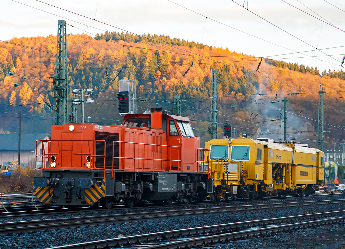 Die 275 870-4 (92 80 1275 870-4 D-BUVL) eine Vossloh MaK G 1206 Mietlok der B & V Leipzig GmbH rauscht mit der P & T Universalstopfmaschine Unimat 08 - 275 3S Y (Schweres Nebenfahrzeug Nr. 97 43 41 523 17 - 9) der DGU (Deutsche Gleisbau Union) am Haken am 18.11.2016 durch Betzdorf/Sieg in Richtung K�ln.