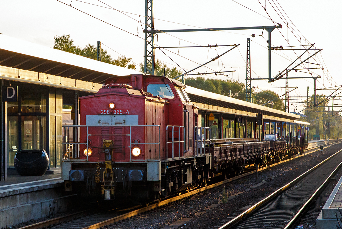 Die 298 329-4 (98 80 3298 329-4 D-DB) eine ehemalige V 100.4, der DB Cargo AG, ex 293 029-5, ex DR 111 029-5, fährt am 19.09.2019, mit drei Flachwagen, durch den Hauptbahnhof Brandenburg an der Havel in Richtung Berlin.

Die V 100.4 wurde 1983 bei LEW (VEB Lokomotivbau Elektrotechnische Werke „Hans Beimler“, Hennigsdorf) unter der Fabriknummer 17718  gebaut und als 111 029-5 an die DR ausgeliefert. Zum 01.01.1992 erfolgte die Umzeichnung in DR 293 029-5 und bereits im August 1992 erfolgte der Umbau und Umzeichnung in DR 298 329-4, bei der DB AG wurde sie 1997 auf Funkfernsteuerung umgebaut.

Im Frühjahr 1978 erhielt die DR mit 110 896-8 ihre zunächst letzte V 100. In der Zwischenzeit zeichnete sich aber Bedarf an weiteren V 100 bei der DR, speziell für den schweren Rangierdienst, und im Bereich der Industrie ab. Vom LEW Hennigsdorf wurde daraufhin die Bauart V 100.3 zur V 100.4 weiterentwickelt, welche über eine höhere Zugkraft verfügte, aber nur eine Höchstgeschwindigkeit von 65 km/h besaß. Die Dampfheizung wurde durch ein Ballastgewicht ersetzt und das Dienstgewicht auf 70 t erhöht. Entsprechend ihrem vorgesehenem Verwendungszweck erhielt die V 100.4 die bekannte orange Lackierung für Rangierloks und spezielle Umlaufgeländer. Nachdem die ersten Loks an Betriebe der DDR mit ausgedehnten Werkbahnanlagen geliefert waren begann auch 1981 die Auslieferung der Baureihe 111 an die Deutsche Reichsbahn.

Die Baureihe 293:
Ab 1992 sah der Umzeichungsplan die neue Baureihe 293 vor. Allerdings erhielten nur 13 Loks diese neue Baureihennummer, die anderen wurden direkt von 111 in 298.3 umgebaut.

Die Baureihe 298.3:
1990 kam man, nach längerer Erprobung der beiden Lokomotiven der Baureihe 108 zu dem Entschluss, dass das hydrodynamische Wendegetriebe auch für die schweren Rangierloks der 111 geeignet wäre. Dieses Getriebe hatte je zwei Vorwärts- und Rückwärtswandler, die zum dynamischen Bremsen genutzt werden konnten. Das neue Getriebe reduzierte so den Verschleiß an den Bremsen und Radreifen und beschleunigte den Richtungswechsel. So wurden die DR BR 111 nach und nach zur Baureihe 298.3 umgebaut. Bis 1993 war der Umbau aller Lokomotiven abgeschlossen. 

2005 erhielten vier Lokomotiven neue 8-Zylinder-Caterpillar-Motoren vom Typ CAT 3508 DI-TA mit 773 kW (1.050 PS) Leistung. 2007 wurden weitere 21 Lokomotiven remotorisiert. Dabei erhielten sie eine neue Hauptgelenkwelle, einen neuen Kühlkreislauf und eine veränderte Abgasanlage mit neuem Schalldämpfer.

TECHNISCHE DATEN (ursprünglich):
Anzahl gebauter Loks: 68
Spurweite: 1.435 mm (Normalspur)
Achsformel: B’B’
Länge über Puffer: 14.240 mm
Breite: 3.140 mm
Drehzapfenabstand: 7.000 mm
Achsstand im Drehgestell: 2.300 mm
Höchstgeschwindigkeit:	65 km/h
Max. Zugkraft:	207 kN
Dauerzugkraft: 142 kN
Motorbauart: 12-Zylinder-Viertakt-Dieselmotor mit Abgasturbolader und Ladeluftkühlung vom Typ 12 KVD 21 A-3 (Hersteller VEB Kühlautomat Berlin-Johannisthal)
Motorleistung: 	736 kW
Getriebebauart: GSR 30/5.7
Getriebeleistung: 736 kW
Dienstgewicht: 70 t
Zugheizung: nein
Vielfachsteuerung 	ja

Nach Umbau und Remotorisierung:
Höchstgeschwindigkeit:	80 km/h 
Motorbauart: Caterpillar V-8-Viertakt-Dieselmotor mit Abgasturbolader und Ladeluftkühlung  vom Typ CAT 3508 DI-TA
Motorleistung: 	773 kW (1.050 PS) 
Motornenndrehzahl: 1.800 U/min
Hubraum: 34,5 l (Bohrung Ø 170 mm / Hub 190 mm)

Quellen: Wikipedia und v100-online.de

