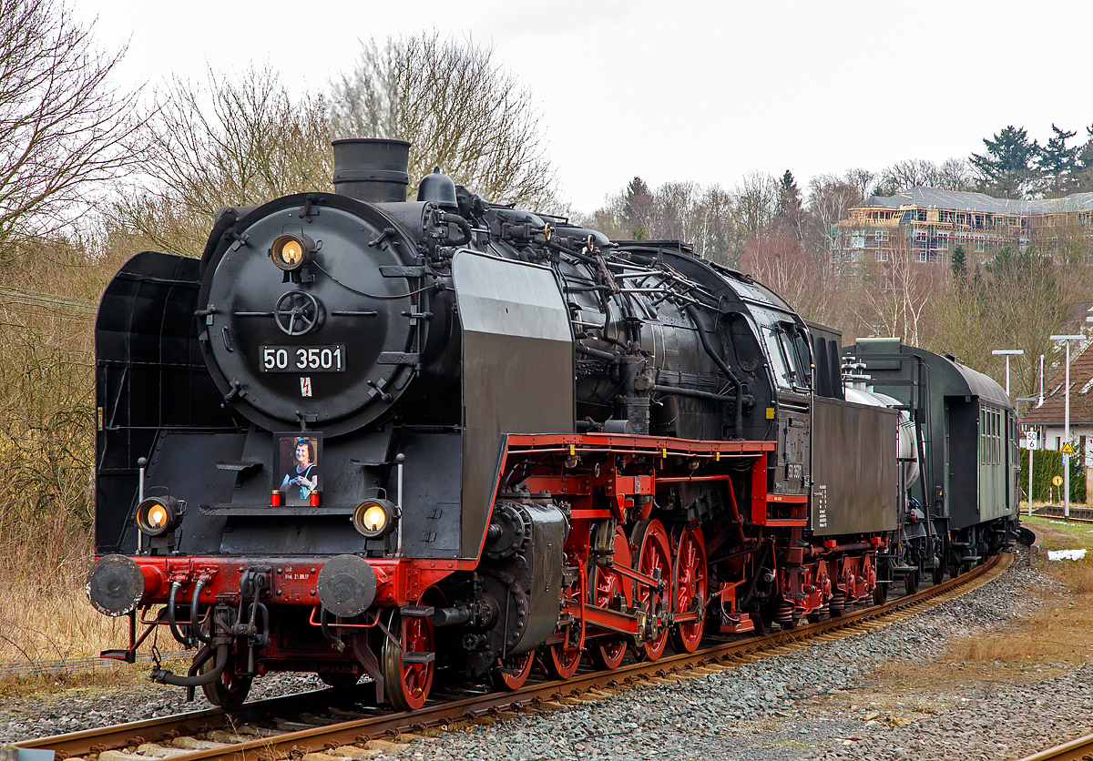 
Die 50 3501-9 des Meininger Dampflokwerkes, ex DR 50 3501-9, ex DR 50 380, am 03.02.2018 mit eine Dampfsonderzug der Eisenbahnfreunde Treysa e.V. in Hachenburg (Westerwald). 

Die heutige Werkslok des Meininger Dampflokwerkes wurde im Jahre 1940 von den Borsig Lokomotivwerken in Hennigsdorf bei Berlin unter der Fabriknummer 14970 gebaut und als 50 380 an die DRB geliefert. Nach der Rekonstruktion im Raw Stendal am 12.November 1957 wurde sie beim Bw Güsten beheimatet, wo sie elf Jahre, bis Juli 1968 im Einsatz stand. Seit 1971 ist die Lok mit einem Tender vom Typ  2'2' T26 (von Lok 50 3706) gekuppelt, dieser wurde 1941 von der Lokomotivfabrik Jung (Jungenthal bei Kirchen) unter der Fabriknummer 9288 gebaut, dieser war mit der 50 2883 geliefert worden.

Am 17. Dezember 1986 kam die 50 3501-9 ins Raw  Helmut Scholz  Meiningen. Dort erhielt sie eine L7 Ausbesserung und wurde umgebaut, um fortan als Werkslokomotive des Raw für das Neubauprogramm von Dampfspeicherlokomotiven Typ FLC zum Aufdampfen und Durchführung der Probefahrten eingesetzt zu werden. Eigens dafür wurde der Mischvorwärmer ausgebaut, eine zweite Strahlpumpe installiert und ein Rohrstutzen an der rechten Einströmung für betriebliche Heizzwecke angeordnet.

Erst mehrere Jahre später, bei einer Kesselrevision, bekam die Lok wieder einen Vorwärmer eingebaut, da sie seit geraumer Zeit wieder vorwiegend bei Sonderfahrten im Streckendienst unterwegs ist. Paradoxerweise jedoch keinen Mischvorwärmer der Bauart IfS, wie es für die Reko-Loks der DR typisch ist, sondern einen Oberflächenvorwärmer der Bauart Knorr, wie sie ihn schon vor der Rekonstrukion besaß.

Im Dezember 2007 brachte eine weitere optische Veränderung an der Maschine mit sich. Im heimatlichen Dampflokwerk wurden die kleinen Windleitbleche der Bauart  Witte  durch große Windleitbleche (Bauart „Wagner ) ersetzt. Diese trug die 50 380 auch bei ihrer Anlieferung 1940. Vom Rekokessel mit dem zugehörigen Aschkasten,  sowie den silberfarbenen Rangiergriffen an der vorderen Pufferbohle abgesehen, entspricht der optische Zustand der Lokomotive damit weitgehend dem einer Altbau-50er aus früheren Tagen.

Geschichte der BR 50:
Ende der 1930er Jahre dachte man, mit dem Stahl St 47 K-Mo einen geeigneten Kesselwerkstoff gefunden zu haben, mit dem sich der Kesseldruck auf 20 bar heraufsetzen lässt, ohne dass sich dadurch das Kesselgewicht insgesamt wesentlich erhöht. Der neu entwickelte Stahl besaß zwar eine höhere Festigkeit als die bislang verwendete Stahlsorte St 34, als Nachteil erwies sich aber die wesentlich schlechtere Wärmeleitfähigkeit. Im harten Alltagseinsatz der Dampflokomotiven ermüdete das Material dadurch sehr rasch, sodass die mit der neuen Stahlsorte angefertigten Kessel schon nach wenigen Jahren ausgetauscht werden mussten. Auch die Baureihe 50 erhielt anfänglich solche Kessel. Auch wenn ihr Zustand weniger kritisch als bei anderen Baureihen war, musste Ende der 1950er Jahre dringend für Ersatz gesorgt werden. Die Deutsche Reichsbahn ließ daher auf Grundlage des Neubaukessels der Baureihe 23.10 / 50.40 den Ersatzkessel 50E entwickeln, der wegen des abweichenden Rahmens einen 500 mm längeren Langkessel erhielt. Er wurde später auch zur Rekonstruktion der Baureihen 23, 52 zur 52.80 und 58 zur 58.30 verwendet. Zwischen November 1957 und September 1962 erhielten 208 Lokomotiven der Baureihe 50 einen solchen Kessel mit einem Mischvorwärmer, größerer Strahlungsheizfläche und verbessertem Saugzug, was auch ihre Leistungsfähigkeit erhöhte. Diese Rekolokomotiven erhielten die Baureihenbezeichnung 50.35 und die Betriebsnummern von 50 3501 bis 50 3708.

TECHNISCHE DATEN:
Nummerierung:  50 3501–50 3708
Anzahl der Rekonstruktionen : 208 (1957 bis 1962)
Spurweite:  1.435 mm (Normalspur)
Bauart: 1’E h2
Gattung:  G 56.15
Länge über Puffer:  22.940 mm
Dienstgewicht:  88,2 t  
Dienstgewicht: Lok und Tender: 140 t
Radsatzfahrmasse:  15,1 t
Höchstgeschwindigkeit: 80/50 km/h (vor-/rückwärts)
Indizierte Leistung: 1.760 PSi
Kuppelraddurchmesser:  1.400 mm
Laufraddurchmesser vorn:  850 mm
Steuerungsart:  Heusinger mit Hängeeisen
Zylinderanzahl:  2
Zylinderdurchmesser:  600 mm
Kolbenhub:  660 mm
Kesselüberdruck: 16 bar
Tender:  2’2’ T 26
Wasservorrat: 26 m³ 
Brennstoffvorrat: 8 t (Kohle)
Zugheizung:  Dampf