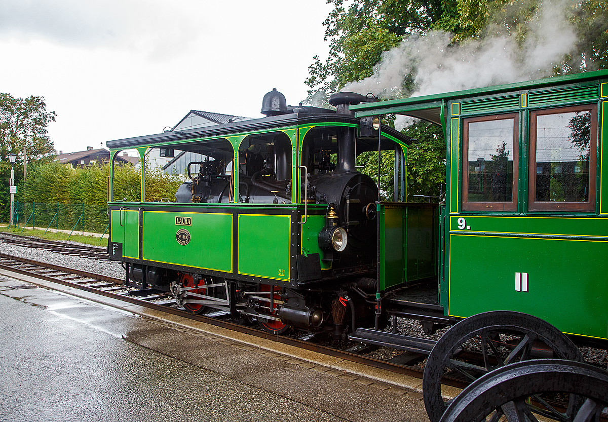 Die „LAURA“ dampft wieder....
Die älteste betriebsfähige Dampf-Lokomotive der Welt, die Krauss L VII Kastendampflokomotive Nr. 1  Laura  der Chiemsee-Bahn steht am 11.09.2022 im Bahnhof Prien am Chiemsee, mit ihrem Personenzug im Bahnhof Prien Bahnhof und Prien Hafen/Stock am Chiemsee, zur Abfahrt bereit. Der Bahnhof der meterspurigen Chiemsee-Bahn liegt direkt neben dem Normalspur Bahnhof der DB.

„Laura“ wurde im Jahre 1887 von der Locomotivfabrik Krauss & Comp. (vom Typ L VII) mit der Fabriknummer 1813 gebaut und ist seit ihrer Auslieferung (ersten Tag) bei der Chiemsee-Bahn auf der Strecke zwischen Prien Bahnhof und Prien Hafen/Stock am Chiemsee im Einsatz. Diese Maschine mit der Achsformel B n2t wurde für seinerzeit 12.500 Goldmark in Auftrag gegeben. Mit ihren 135 Dienstjahren gehört sie somit zu den ältesten, betriebsfähigen Dampflokomotiven der Welt.

Wesentliche Überholungsarbeiten fanden im Jahr 1937 statt, als eine neue Feuerbüchse aus Kupfer eingepasst wurde. Einen Ersatzkessel, der eine Leistungssteigerung von 60 auf 100 PS mit sich brachte, bekam die Lok im Winter 1957/1958. Zwischen 2018 und 2021 erfolgte im Dampflokwerk Meiningen eine neuerliche Aufarbeitung, u. a. mit Einbau eines neuen Kessels in geschweißter Ausführung. Ihre ersten Probefahrten machte sie dann im März 2021 auf den Harzer Schmalspurbahnen.

TECHNISCHE DATEN:
Hersteller: Krauss & Comp., München (Fabriknummer 1813)
Baujahr: 1887
Kessel seit 2021: DLW (Dampflokwerk Meiningen),Baujahr 2021
Kessel 1957 bis 2021: Jung, Baujahr 1950 (Fabriknummer 10848)
Kessel ursprünglich bis 1957: Krauss
Typ: L VII Kastendampflokomotive
Achsfolge: B 
Bauart:  Bn2t
Länge ü. Puffer: 	5.100 mm
Achsstand: 1.800 mm
Höchstgeschwindigkeit: 25 km/h
Indizierte Leistung: 100 PS (ursprünglich 60 PS)
Anfahrzugkraft: 	57,8 kN
Leergewicht: 10,7 t
Dienstgewicht:13,3 t
Kohlvorrat: 0,6 t
Wasservorrat: 1,12 m³
Zylinderdurchmesser: 	225 mm
Kolbenhub: 350 mm
Treibraddurchmesser: 800 mm
Kesselüberdruck: 13 bar
Kulissensteuerung:   Stephenson

Als Ludwig II. im Jahr 1886 starb, ließ dessen Nachfolger Prinzregent Luitpold die Bauarbeiten am Schloss Herrenchiemsee einstellen und gab den Prachtbau für die Öffentlichkeit frei. Dadurch verzeichnete besonders die Herreninsel einen wahren Besucheransturm, aber auch die lieblichere Fraueninsel und die dort ansässigen Gastronomiebetriebe lockten bereits damals viele Touristen an.

Die Königlich Bayerischen Staats-Eisenbahnen brachten die Besucher aus München, Rosenheim und Salzburg nach Prien. Der knapp zwei Kilometer entfernte Hafen konnte vom Bahnhof Prien mit einem von der örtlichen Bevölkerung organisierten Fahrdienst erreicht werden, dieser bestand aus Kutschen und Karren. In der dörflichen Enge entstand dadurch ein erhebliches Verkehrschaos, diese Zustände kannte man zuvor nur aus der „großen Stadt“.

Bereits kurz nach dem ersten großen Ansturm auf Herrenchiemsee beantragten der Schifffahrtbetreiber Ludwig Feßler sowie der Kommerzienrat Georg Krauß aus München (Gründer der Lokomotivfabrik Krauß & Comp.) noch 1886 den Bau einer schmalspurigen Lokalbahn vom Bahnhof Prien zum Dampfersteg in Stock. Planung und Ausführung erfolgten mit einem für die damalige Zeit bemerkenswerten Tempo. Die Bauarbeiten begannen am 2. Mai 1887, schon am 21. Juni waren die Schwellen verlegt und man begann mit dem Aufnageln der Schienen. Die feierliche Eröffnung der Bahn fand nach weniger als 70 Tagen Bauzeit am 9. Juli 1887 statt. Bereits am nächsten Tag, einem Sonntag, nahm sie den offiziellen Betrieb auf. 

Für den Betrieb bestellt man bei der Lokomotivfabrik Krauss & Comp. in München diese L VII Kastenlokomotive (Straßenbahnlokomotive), die 1887 von Krauss & Comp. unter der Fabriknummer 1813 gebaut und an die Chiemsee-Bahn geliefert wurde. Solche zweifach-gekuppelte Nassdampflok vom gleichen Typ, die für den Ein-Mann-Betrieb ausgelegt sind, wurde auch an andere Bahngesellschaften geliefert. 

Seit dem 9. Juli 1887 fährt nun diese Lokomotive bis heute zwischen Prien Bahnhof und Prien Hafen/Stock. Sie ist damit eine der ältesten betriebsfähigen Dampf-Lokomotiven der Welt.

