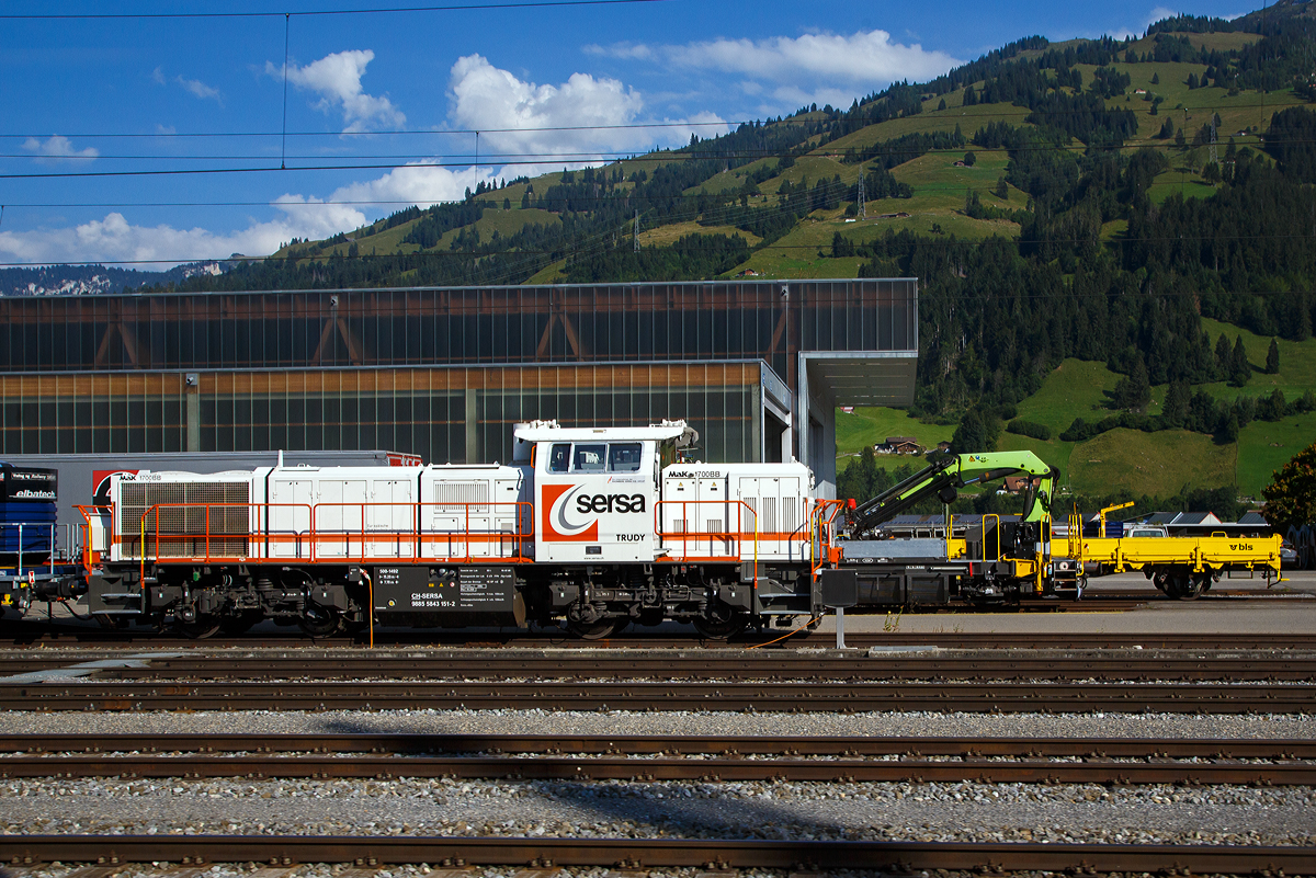 Die Am 843 151 „Trudy“ (98 85 5843 151-2 CH-SERSA) der Sersa (Rhomberg Sersa Rail Group), eine Schweizer Version der MaK G 1700-2 BB, ist am 08.09.2021 in Frutigen abgestellt (aufgenommen aus einem Zug).

Die Am 843 wurde 2004 von Vossloh in Kiel (ehem. MaK) unter der Fabriknummer 5001492 gebaut und an die Sersa AG (CH) geliefert. Die angeschriebene Bezeichnung „MaK G 1700 BB“ ist eigentlich nicht ganz richtig, denn die Schweizer Version Am 843 unterscheidet sich etwas von der MaK G 1700 BB.

Die Schweizerischen Bundesbahnen (SBB) bestellten bei Vossloh zunächst 59 Lokomotiven der Baureihe Am 843. Diese Lokomotiven werden im schweren Rangier- und leichten Streckendienst eingesetzt. Dazu gehört neben dem Rangierdienst in den größeren Rangierbahnhöfen und auf Stationen auch der Zustelldienst mit Streckenfahrten im Nahbereich. Ein weiteres Einsatzgebiet für die Lokomotiven besteht im Bau- und Interventionsdienst.

Um die Am 843 für diese sehr unterschiedlichen Aufgaben möglichst gut anzupassen fiel die Wahl auf eine der G1206 sehr ähnliche Maschinenanlage. Das Turbowendegetriebe L 5r4 z wurde in einer Version als Stufengetriebe verwendet. Es besetzt einen Rangiergang mit 40 km/h Höchstgeschwindigkeit und hohen Zugkräften im unteren Geschwindigkeitsbereich, sowie einen Streckengang mit 100 km/h Höchstgeschwindigkeit. Der Motor bleib dagegen der gleiche und leistet unverändert .1500 kW.

Für die übrigen Komponenten bediente man sich bei der Entwicklung der Am 843 jedoch der wesentlich jüngeren G 1700-2 BB, die den hohen Komfortwünschen der SBB gerecht wurden und deutlich mehr Einbauräume für diversen Sonderausrüstungen, z. B. die schweizerischen Zugsicherungen Integra Signum und ZUB 262 ct bietet. Trotzdem unterscheidet sich die Am 843 durch das Linksführerhaus und die für die Schweiz typischen eckigen Lampen und Geländer mit Schutzblechen schon äußerlich deutlich von ihr. Eine weitere Besonderheit ist der Partikelfilter zur Reduzierung des Rußausstoßes, die erstmals bei einer Lokmotive dieser Leistungsklasse in Serie eingebaut wurde.

Im Herbst 2003 begann die Lieferung die ersten Loks. Weitere Lokomotiven der Baureihe Am 843 konnten an andere Bahnen in der Schweiz verkauft werden. Zunächst erhielt das Bauunternehmen Sersa AG im Sommer 2004 drei Lokomotiven, die bei der Ausrüstung des Lötschberg-Basistunnels eingesetzt wurden. Für den gleichen Tunnel, jedoch für den Bau- und Interventionsdienst im regulären Betrieb erhielt die BLS zwei Jahre später ebenfalls drei Am 843. Als Besonderheit erhielten die BLS-Loks die europäische Zugsicherung ETCS, die im neuen Tunnel verwendet wird.

Der Lokrahmen besteht aus Walzträgern und massiven Blechen, welche in Schweißkonstruktion miteinander verbunden wurden. Dadurch entsteht ein stabiler und robuster Grundaufbau, welcher der Lok die notwendigen Festigkeiten verleiht. Im Lokrahmen wurde eine so genannte Umweltwanne montiert, welche aus dem Fahrmotor austretenden Flüssigkeiten (Mineralölen und Wasseremulsionen) auffängt, diese können mit Hilfe eines Ablasshahnes entleert und fachmännisch entsorgt werden.

Der vordere längere Vorbau beinhaltet neben dem Dieselmotor auch die notwendige Kühlanlage und das Antriebsgetriebe. Der kürzere hintere Vorbau enthält neben der Druckluftanlage auch die elektrischen Komponenten wie die Batterieladung.

Zwischen den beiden Vorbauten befindet sich das Mittelführerhaus, welches über die zwei diagonal gegenüberliegenden Eingangstüren betreten werden kann. In ihm sind alle für den Lokführer notwendigen Einbauten vorhanden. Ein Führersitz je Fahrpult und Fahrrichtung, welcher mit Arm- und Rückenlehnen ausgerüstet ist, erlaubt die sitzende Bedienung der Lokomotive. Dieser Führersitz ist drehbar gelagert und kann zusammengeklappt und unter den Führertisch verschoben werden. Dadurch ist auch die stehende Bedienung der Lokomotive ohne Behinderung möglich. Zur Entlastung der Füße sind auch verstellbare Fußstützen montiert. Der Fußboden ist mit einem Profilgummibelag belegt worden, der eine einfache Reinigung und dennoch einen guten Stand erlaubt.

Angetrieben wird die Lokomotive von einem 12-Zylinder-4Takt-Dieselmotor vom Typ Caterpillar 3512 B DI-TA-SCAC, dieser erbringt mit Hilfe der beiden Abgasturbolader und der Ladeluftkühlung eine maximale Leistung von 1.500 KW (2.040 PS). Seine höchste Drehzahl beträgt 1.800 U/min. Er wird mit Hilfe eines elektrischen Anlassers gestartet und ist elektronisch geregelt. Dadurch ist es möglich, den Motor bestmöglich im optimalen Leistungsbereich zu betreiben. Sein Gewicht beträgt mit 322 Liter Schmieröl und 134 Liter Kühlwasser 7.700 kg.

Die vom Dieselmotor erzeugte Leistung wird mittels einer Gelenkwelle auf das hydrodynamische Getriebe (Turbowendegetriebe), vom Typ Voith L5r4zseU2, übertragen. Das Getriebe hat eine maximale Leistung von 1.400 kW. Es beschränkt somit die Leistung der Lokomotive und verhindert zugleich, dass der Fahrmotor überlastet werden kann. Seine maximale Drehzahl ist gleich groß, wie jene des Fahrmotors.

Das Turbowendegetriebe besitzt für jede Fahrrichtung zwei Drehmomentwandler. Dem eigentlichen Wandlergetriebe ist eine mechanische Getriebe nachgeschaltet, das eine niedrige für den Rangierbetrieb bestimmte Schaltung und eine höhere für den Streckenbetrieb bestimmte Schaltung zur Verfügung zu stellen. Diese Umschaltung darf jedoch erst im Stillstand erfolgen.

Die Achsen in den Drehgestellen werden über Gelenkwellen vom Turbowendegetriebe angetrieben. Die Übertragung auf die Achsen erfolgt mit Hilfe von Stirnradgetrieben mit Kegelradvorgelege.

Technische Daten:
Gebaute Anzahl: 79
Spurweite: 1.435 mm (Normalspur)
Achsformel: B'B'
Länge über Puffer: 15.200 mm
Höhe: 4.220 mm
Breite: 3.080 mm
Drehzapfenabstand: 7.700 mm
Achsstand im Drehgestell: 2.400 mm
Dienstgewicht: 80 t
Höchstgeschwindigkeit: 100 km/h (40 km im Rangiergang)
Installierte Leistung: 1.500 kW (2.040 PS)
Anfahrzugkraft: 249 kN
Treibraddurchmesser: 1.000 mm
Motorentyp: Caterpillar 3512B DI-TA-SCAC
Nenndrehzahl: 1.800/min
Getriebe:  Voith Typ L 5r4 zseU2  
Kleinster bef. Halbmesser: 60 m
Tankinhalt: 3.500 l
