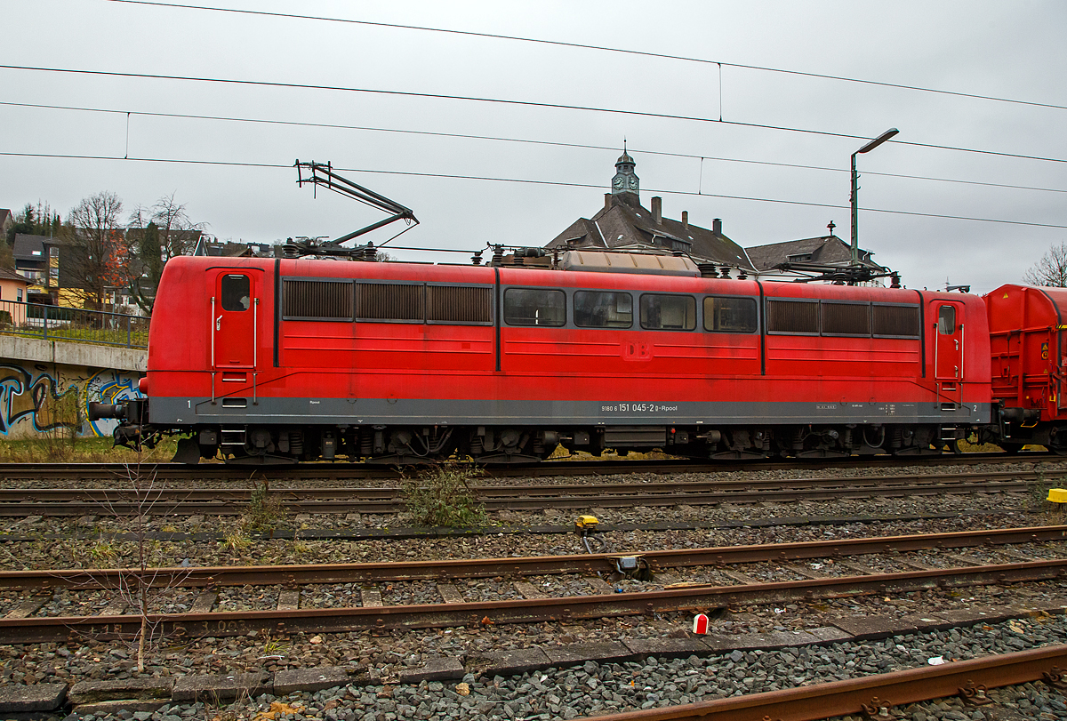 Die an die DB Cargo AG vermietete Railpool 151 045-2 (91 80 6151 045-2 D-Rpool) fährt am 04.12.2021 mit einem Coilzug durch Niederschelden in Richtung Köln.

Die Lok wurde 1974 von der Krauss-Maffei AG in München-Allach unter der Fabriknummer 19664 gebaut und an die Deutsche Bundesbahn geliefert. Bis 31.12.2016 gehörte sie zur DB Cargo AG. Zum 01.01.2017 wurden je 100 sechsachsige elektrische Altbau-Lokomotiven der Baureihen 151 und 155 an ein Konsortium aus dem Lokvermieter Railpool verkauft. Die DB Cargo mietet daraufhin 100 Loks von Railpool wieder an. Die anderen Maschinen werden dem freien Markt angeboten. Den Sinn dahinter kann man nicht ganz verstehen.
