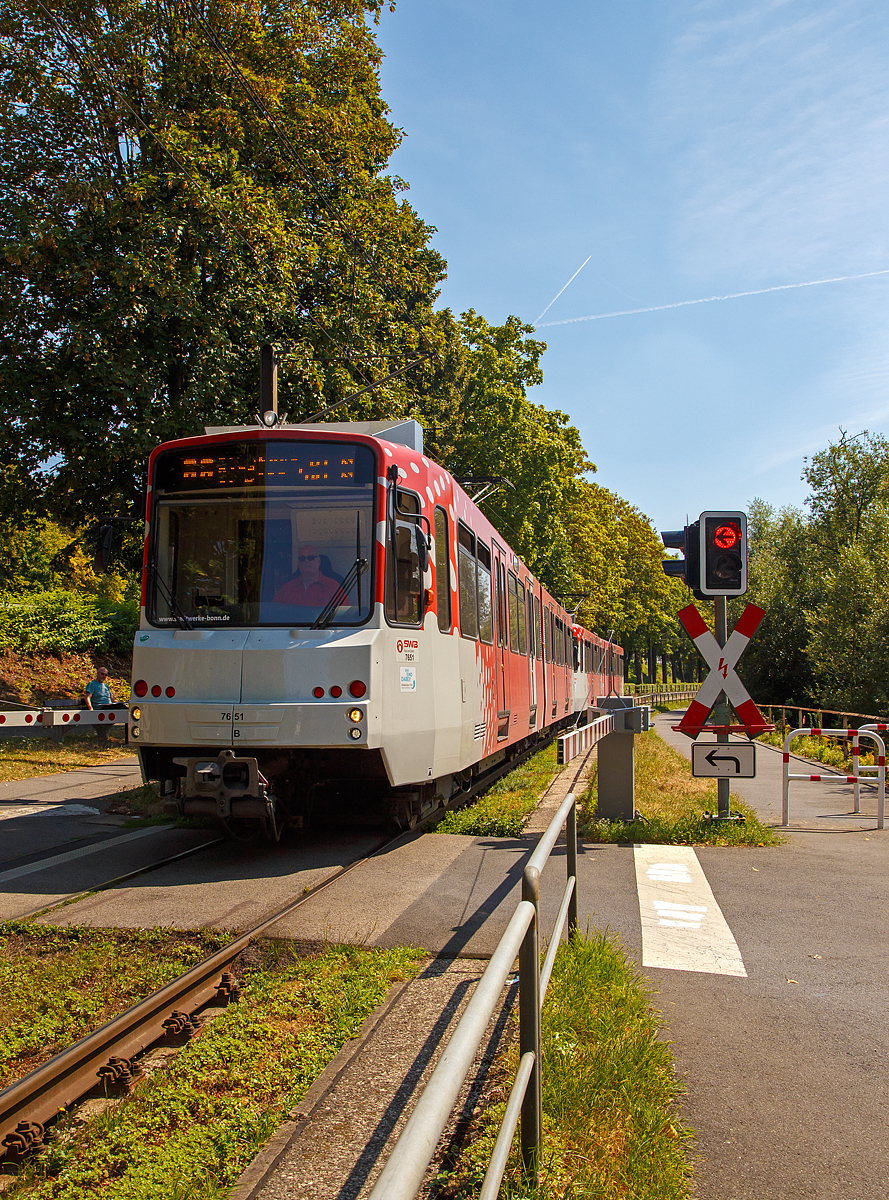 
Die beiden gekuppelten Triebwagen 7651 und 7459 der SWB (Stadtwerke Bonn Verkehrs GmbH), zwei modernisierte DUEWAG Stadtbahnwagen vom Typ B 80C (ex B 100S) fahren am 18.08.2018, als Linie 66 nach Siegburg Bf über Bonn Hbf, hier passieren sie gleich den Bü  Am Steinchen  in Bad Honnef.