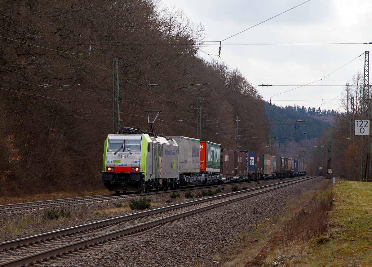 Die BLS Cargo 507, Re 486 507-7 (91 85 4486 507-7 CH-BLSC) fährt am 26.03.202, mit einem KLV-Zug, bei Dillbrecht über Dillstrecke (KBS 445) in nördlicher Richtung.

Die TRAXX F140 MS2E wurde 2008 von Bombardier in Kassel unter der Fabriknummer 34426 gebaut und an die BLS Cargo geliefert. Die Loks sind nur für die Schweiz, Deutschland, Italien und Österreich zugelassen.

Der Erfolg im Güterverkehr veranlasste die BLS zehn weitere TRAXX zu bestellen im Gegensatz zur ersten Serie TRAXX F140 AC1 mit der Bezeichnung Re 485 001 bis 485 020, die nur unter Wechselstrom fahren können, können die TRAXX F140 MS Re 486 501 bis 486 510 auch unter 3.000 Volt Gleichstrom eingesetzt werden. Bombardier hatte seit der ersten Lieferung Verbesserungen vorgenommen. Dabei wurde der Lokomotivkasten optimiert und die Traktionsausrüstung mit moderneren Komponenten versehen. Eine Nachbeschaffung wäre noch möglich gewesen, hätte aber dazu geführt, dass die Lokomotiven nicht auf dem neuesten Stand waren und nicht unter der Gleichstromfahrleitung eingesetzt werden konnten. Die eingebauten Zugbeeinflussungssysteme erlauben den Einsatz in Deutschland, Österreich, der Schweiz und Italien (DACHI). Anfänglich waren die Lokomotiven in der Schweiz nur für den Einsatz auf Strecken mit konventioneller Zugbeinflussung und nicht auf ETCS Level 2-Strecken zugelassen. Die Re 486 können unter sich und mit den Re 485 und Lokomotiven der Baureihe 185/186 in Vielfachsteuerung eingesetzt werden.

TECHNISCHE DATEN:
Spurweite:  1.435 mm (Normalspur)
Achsformel:  Bo’Bo’
Länge über Puffer:  18.900 mm
Höhe:  4.385 mm
Breite:  2.978 mm
Drehzapfenabstand:  10.400 mm
Achsabstand im Drehgestell: 2.600 mm
Dienstmasse:  85 t
Höchstgeschwindigkeit:  140 km/h
Dauerleistung:  5.600 kW
Dauerzugkraft:  300 kN
Treibraddurchmesser:  1.250 mm
Stromsysteme:  15 kV 16,7 Hz, 25 kV 50 Hz Wechselstrom sowie 3 kV und 1,5 kV Gleichstrom
Antrieb:  Tatzlager