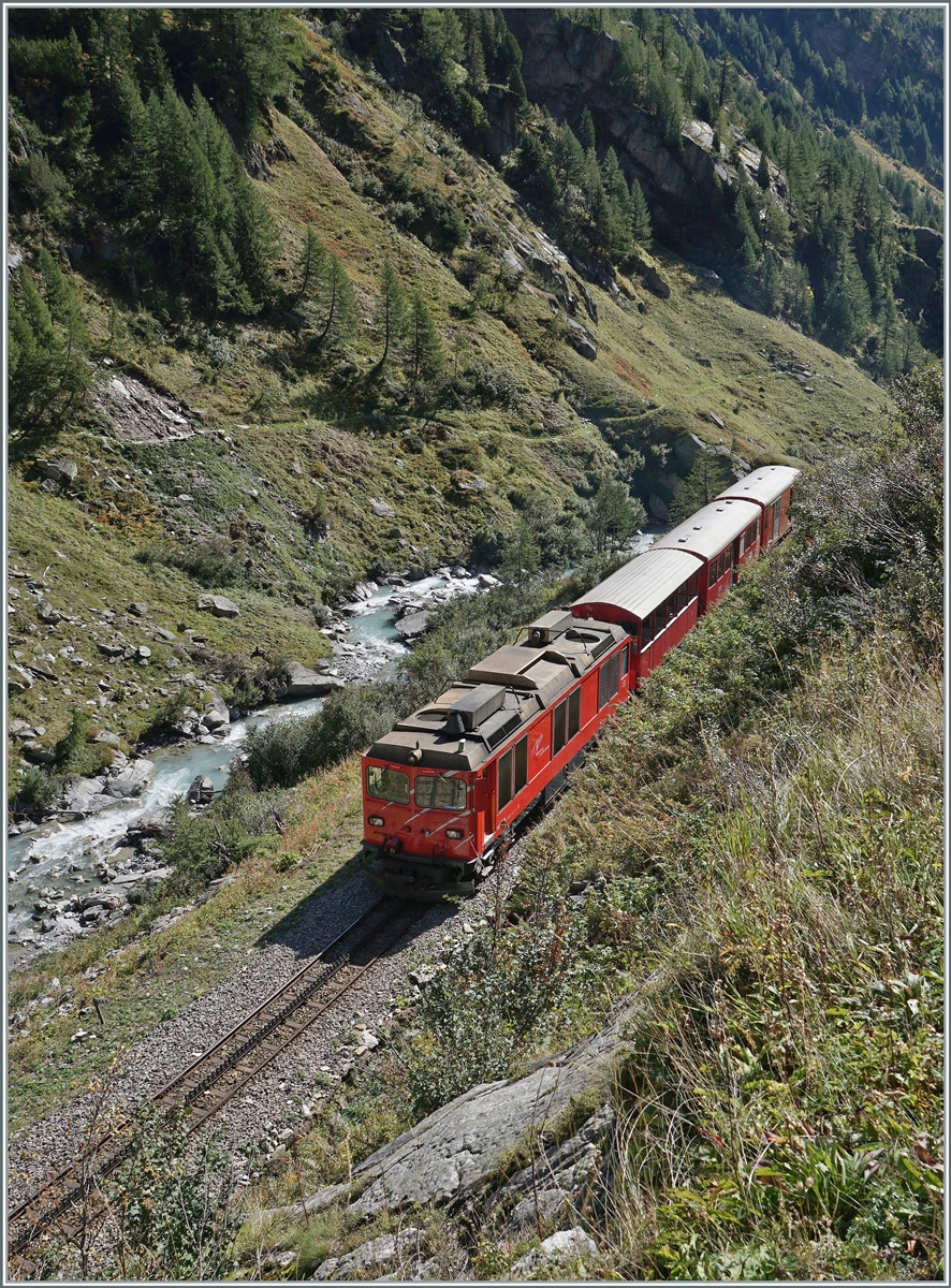 Die DFB HGm 4/4 61 ist mit ihrem Dieselzug 238 von Oberwald nach Gletsch unterwegs und erreicht in wenigen Minuten den 548 Meter langen  Gletsch  Kehrtunnel. Im linken Bildteil sieht man die noch junge Rhone in Tal hinunter plätschern. 

30. September 2021