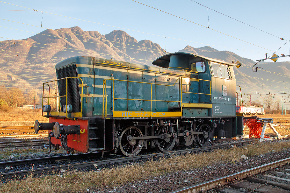 
Die Dieselrangierlok D.245.442-8 (98 83 2245 442-8 I-TI) der Trenitalia (100-prozentige Tochtergesellschaft der FS), ex FS 245.2242, abgestellt am 27.12.2015 im Bahnhofsareal in Domodossola.

Die FS (Ferrovie dello Stato Italiane S.p.A. / Italienische Staatseisenbahnen AG) führte 1963 die Reihe D.245 als leistungsfähigste Rangierlok ein. Die dreiachsigen Kraftpakete (Achsfolge C) wurden von verschiedenen Firmen in unterschiedlichen Formen geliefert. 

Die Formen ergeben sich aus den unterschiedlichen Serien, Herstellern und Baujahren und sind wie folgt:
245.6001–6124, Baujahre 1963 bis 1969, Cantieri Navali Riuniti/OM/Jenbacher Werke
245.0001–0058, Baujahre 1964 bis 1968, Hersteller: Antonio Badoni/OM
245.1001–1020, Baujahre 1964 bis 1968, Hersteller: OM/FIAT-Mercedes-Benz
245.2001–2020, Baujahr 1966, Hersteller: Officine Meccaniche Reggiane/Breda
245.2101–2286, Baujahre 1976 bis 1987, Hersteller: Breda/Antonio Badoni/Greco/Ferrosud/IMMER
245.8001–8003, Baujahre 1958 bis 1962, dies waren später von der FS von einem Unternehmen erworben drei Lokomotiven vom Typ Jung R42C, die später zur Hafenbahn Genua kamen. 

Die hier gezeigte Lok 245.2242 wurde 1984 von Breda und Greco gebaut. Die Serie 245.2101–2286 ist optisch baugleich mit der Serie 245.20 aus dem Jahr 1966, nur geringe Modifikationen wurden vorgenommen und die Kuppelstangen-Lager wurden als Rollenlager ausgeführt, anstelle der Gleitlager.
                                                                                                                                                                                                                    
Sie hat ein hydraulisches Getriebe und Stangenantrieb. Die Achsen werden mittels Kuppelstangen von einer Blindwelle (zwischen der 2. Und 3. Achse) angetrieben. Die Lok hat einen, von 440 auf 370 kW, gedrosselten 12-Zylinderdieselmotor vom Typ Breda ID36, der die Leistung auf das Voith Strömungsgetriebe (hydrostatisch), vom Typ L24. Die Dauerabtriebsleistung beträgt 275 kW. Die Kraftübertragung erfolgt über eine zwischen dem 2. und 3. Radsatz liegenden Blindwelle, Blindwellenkurbeln an den beiden Blindwellenenden und Kuppelstangen auf die Räder der Lok.
 
Technische Daten:
Spurweite:  1.435 mm (Normalspur)
Achsformel:  C
Länge über Puffer: 9.240 mm
Achsabstände:  1.500 / 2.500 mm
Eigengewicht:  46 t
Höchstgeschwindigkeit:  64 km/h (im Rangiergang 32 km/h)
Motorleistung:  370 kW
Dauerleistung:  275 kW
Treibraddurchmesser:  1.040 mm