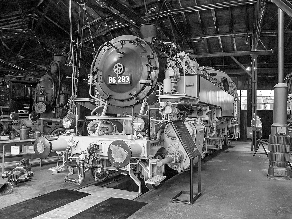 Die Einheits-Güterzugtenderlokomotive 86 283 im hellgrau-schwarzen Fotoanstrich, ex  DB 086 283-9, am 26.03.2016 Deutschen Dampflokomotiv-Museum in Neuenmarkt-Wirsberg.

Die 1D1-Tenderlokomotive (vierfach gekuppelte Tenderlokomotive) wurde 1937 von 	Orenstein & Koppel  in Babelsberg unter der Fabriknummer 12912 gebaut DRG geliefert. Nach dem Krieg blieb sie im Westen und kam so zur Deutschen Bundesbahn, wo sie nach dem EDV-Nummernplan 1968 in DB 086 283-9 umgezeichnet wurde. Im Jahr 1974 wurde sie dann bei der DB ausgemustert.

Die Baureihe 86 wurde als Einheits-Güterzugtenderlokomotive von der Deutschen Reichsbahn entworfen. Sie war für den Einsatz auf den Nebenstrecken vorgesehen und wurde von fast allen für die Reichsbahn tätigen Unternehmen geliefert. Die ersten Lieferungen (wie diese hier) waren noch mit Bissel-Laufachsen ausgerüstet, die Maschinen mit den Betriebsnummern 86 293-296 und ab der Nummer 86 336 erhielten aber dann Krauss-Helmholtz-Gestelle. Dadurch konnte die Höchstgeschwindigkeit von 70 auf 80 km/h heraufgesetzt werden, die Gesamtlänge wuchs auf 13.920 mm. Ab 1942 wurde sie in einer vereinfachten Form als Übergangskriegslokomotive (ÜK) gebaut. Im Zeitraum von 1928 bis 1943 wurden 775 Exemplare gebaut, von denen alle bis auf zwei Maschinen nach dem Zweiten Weltkrieg wieder aufgefunden wurden. 

385 Maschinen verblieben auf dem Netz der Deutschen Bundesbahn in Westdeutschland, wovon 8 Lokomotiven wegen Kriegsschäden bis 1952 ausgemustert wurden. Die Deutsche Reichsbahn konnte nach Abgabe von 71 Loks an die Sowjetischen Eisenbahnen (S´D) von dann noch vorhandenen 172 Exemplaren 164 in den Betriebsbestand aufnehmen.

TECHNISCHE DATEN (dieser Lok bzw. der ersten Serien):
Spurweite: 	1435 mm (Normalspur)
Achsformel: 1'D1'
Bauart: 1'D1' h2t
Gattung: Gt 46.15
Länge über Puffer: 13.820 mm
Höhe: 4.165 mm
Kleinster bef. Halbmesser: 	140 m
Leergewicht: 70,0 t
Dienstgewicht: 88,5 t
Achslast:15,6 t
Höchstgeschwindigkeit :70 km/h (vorwärts und rückwärts)  
Indizierte Leistung: 1031 PSi
Kuppelraddurchmesser: 1.400 mm
Laufraddurchmesser (vorn / hinten): 850 mm
Steuerungsart: außenliegende Heusinger-Steuerung
Zylinderanzahl: 	2
Zylinderdurchmesser: 	570 mm
Kolbenhub: 660 mm
Kessellänge: 4.500 mm
Kesselüberdruck: 14 kp/cm² (14 bar)
Wasservorrat: 9,0 m³
Kohlevorrat: 4,0 t

Laufleistung der 82 283 über 1,5 Mio. km
