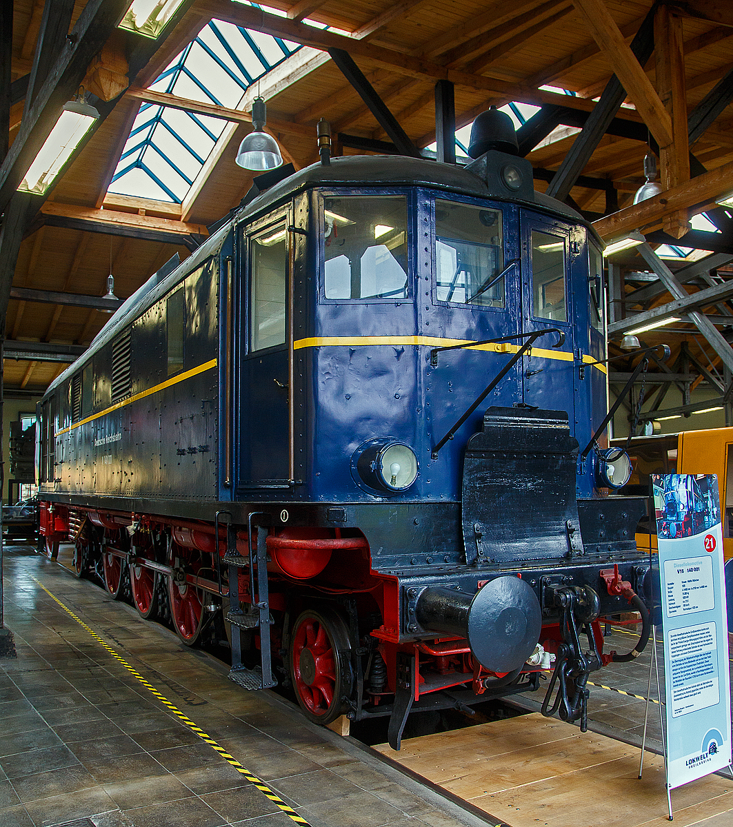 Die ex DB/DR V 140 00, ex  DR V 16 101, am 11.09.2022 in der Lokwelt Freilassing. Die Lok ist eine Leihgabe vom Deutschen Museum an die Lokwelt Freilassing.

Die Lok wurde 1935 von Krauss-Maffei in M�nchen unter der Fabriknummer 15528 gebaut, der Dieselmotor ist von MAN Augsburg das Turbo-Getriebe von J.M. Voith-Heidenheim, die elektrische Ausr�stung BBC-Mannheim.

Die V 140 001 (V 16 101) ist eine Diesellokomotive der Deutschen Reichsbahn (DR). Sie war die erste dieselhydraulische Gro�lokomotive, mit Leistung von �ber 1.000 kW. Sie konnte sich durchaus mit gr��eren Dampfloks messen, wobei ihr der Wirkungsgrad h�her und der Wartungsaufwand geringer war. Entscheidend war das eigen f�r diese Lok entwickelte Getriebe mit zwei hydraulischen Kupplungen und einem Drehmomentwandler. Die �bertragung der Motorkraft erfolgte �ber das hydraulische Getriebe auf eine Blindwelle und von dort �ber Treibstangen auf die drei Kuppelachsen (Treibr�der). Durch den folgenden Zweiten Weltkrieg blieb die Lok doch Einzelst�ck, zudem wurde sie im Krieg wegen dem Treibstoffmangel abgestellt. 

Die DR vergab 1934 den Auftrag zur Entwicklung einer neuen hydraulischen Diesellokomotive mit folgenden Anforderungen: 
Die Lok sollte G�terz�ge von 500 Tonnen auf Steigungen 10 ‰ mit 30 km/h bef�rdern, 100 km/h H�chstgeschwindigkeit fahren, im Wendezugbetrieb ferngesteuert werden, an den Stirnw�nden �bergangst�ren f�r leichte G�terz�ge des St�ckgut-Schnellverkehrs besitzen und die Versorgung der Zugbeleuchtung mit Elektroenergie �bernehmen k�nnen.

Nach diesen Vorgaben entwarf das Reichsbahn-Zentralamt in M�nchen unter Beteiligung der Unternehmen Krauss-Maffei, Voith und MAN diese Lokomotive. Nach nur achtmonatiger Bauzeit war die Lokomotive 1935 so weit fertiggestellt, dass sie zur Feier 100 Jahre Deutsche Eisenbahnen als Ausstellungsst�ck pr�sentiert werden konnte. Nach der endg�ltigen Fertigstellung begann ihre eingehende Erprobung, die positiv verlief. Sie sollte urspr�nglich die Bezeichnung V16 101 tragen, doch nach den ab 1930 g�ltigen Nummerierungsvorschriften erhielt sie die Benennung V 140 001.Bei Streckenfahrten zeigte sich, dass sie der BR 38.10-40 ebenb�rtig war. Die Zugkr�fte stimmten im Kupplungsbereich mit der Vergleichsmaschine �berein, im Wandlerbereich war sie etwas schlechter. Kinderkrankheiten wurden beseitigt, so zeigte sich, dass die K�hlung bestimmter Schmier�lkreisl�ufe nicht n�tig war. Auch die Schaltung f�r das Wendegetriebe war nicht ideal gel�st. Ansonsten erf�llte sie die an sie gestellten Forderungen und wurde als erste Lokomotive mit hydrodynamischem Antrieb gr��erer Leistung auf der Weltfachausstellung Paris 1937 gezeigt, wo sie den Grand Prix erhielt. 

Eingesetzt hat die Reichsbahn sie im Raum M�nchen f�r den Zweigbahn- und Wendezugverkehr. Im Zweiten Weltkrieg musste die Lok wegen Treibstoffmangels abgestellt werden. Sie wurde durch Bombeneinwirkung mehrfach besch�digt. In der Nachkriegszeit wurde sie wieder instand gesetzt und sp�ter sogar noch von der Deutschen Bundesbahn f�r Reisez�ge verwendet. Stationiert war sie im Bahnbetriebswerk Frankfurt-Griesheim. Am 13. Oktober 1953 wurde sie nach einer Laufleistung von insgesamt 130.500 km ausgemustert, weil es f�r dieses Einzelst�ck keine Ersatzteile mehr gab. Auch verf�gte die DB schon �ber die ersten Exemplare der moderneren V 80.

Dennoch war f�r alle weiteren dieselhydraulischen Lokomotiven die Konstruktion der V 140 richtungsweisend, was zur Entscheidung ihrer Erhaltung f�hrte. So kam sie von 1953 bis 1978 zur Technischen Hochschule Karlsruhe als Lehr- und Studienobjekt. Danach gelangte sie zum des Deutschen Museums in M�nchen.

Technische Beschreibung
Die Lokomotive ist vom Aufbau her eine Rahmenlokomotive mit geschlossenem Lokkasten. Der Innenrahmen ist in Schwei�konstruktion hergestellt, der �ber die Pufferbohlen und verschiedene andere Quertr�ger versteift ist. Abgefedert ist er vom Laufwerk �ber Blattfedern. Zwischen den Treibachsen sind diese durch Ausgleichshebel miteinander verbunden. Die prim�re Abfederung ist ebenfalls durch Blattfedern unternommen, sie sind �ber den Achslagern platziert. S�mtliche Lager der Treib- und Laufachsen sind als Gleitlager ausgef�hrt. Die Laufachsen sind Bisselachsen. Die beiden Endf�hrerst�nde besitzen seitliche Aufstiege und in der Stirnseite zum �bergang auf die Wagen �bergangst�ren mit Br�cken. Der dazwischen liegende Maschinenraum ist �ber Klappt�ren zu erreichen. Zum Ausbau der Hauptaggregate konnte das Dach vom Lokkasten abgenommen werden. Im Bereich des K�hlers sowie des Heizkessels konnten die dort platzierten Seitenw�nde ebenfalls vom Lokkasten entfernt werden.

Die Maschinenanlage besteht aus einem Haupt-Dieselmotor von MAN vom Typ W 8 V 30/38 und dem Str�mungsgetriebe JJg 2 M von Voith. Der Dieselmotor ist ein Achtzylinder-Viertakt-Motor mit Turbolader, der bei 700/min Nennleistung von 1.030 kW (1.400 PS) abgab.Das Str�mungsgetriebe besteht aus einem Drehmomentenwandler und zwei Str�mungskupplungen. Nach einem Untersetzungsgetriebe und dann �ber ein Wendegetriebe wurde das Drehmoment auf die Achsen �ber eine Blindwelle �bertragen. Diese sitzt hinter den drei Treibachsen und ist mit diesen durch Treibstangen verbunden.

Ein Hilfs-Dieselmotor von MAN vom Typ WV 15/18, der auf eine Leistung von 88 kW (110 PS) gedrosselt wurde, betrieb einen Generator f�r die Stromversorgung der Zugbeleuchtung mit 220 V. F�r die Zugheizung war ein Dampfkessel von Krauss-Maffei eingebaut, der mit �l gefeuert war. Als Bremse war eine einl�sige Knorr-Druckluftbremse vorhanden, wobei das Str�mungsgetriebe als zus�tzliche Abbremsung eingesetzt werden konnte. Die Lok ist mit den Signaleinrichtungen Dreilicht-Spitzensignal, Druckluftpfeife und L�utewerk ausgestattet.

Die Lokomotive war mit einem Bordnetz von 24 V DC ausger�stet. F�r den Wendezugbetrieb konnte die Lokomotive, durch ein Steuerkabel verbunden, vom Steuerwagen aus gesteuert werden. Lediglich in der Heizperiode musste sie durch einen W�rter zur �berwachung des Heizkessels besetzt werden. Der Dieselmotor wurde durch F�llungsregelung in zehn Fahrstufen gesteuert. Der zehnstufige Fahrschalter steuerte Magnetventile, deren Steuerluft wurde von einem pneumatischen Stellger�t beeinflusst. Das Steuerger�t stellte die erforderliche Einspritzmenge Kraftstoff ein. Elektropneumatisch wurde auch das Wendegetriebe umgesteuert. Es konnte erst umgesteuert werden, wenn der Fahrschalter auf 0 gestellt war. Andersherum konnte die Lok nicht anfahren, wenn das Wendegetriebe nicht in Endstellung war, die durch Endkontakte und Federkraft gesichert waren.

TECHNISCHE DATEN:
Gebaute Anzahl: 1
Hersteller: 	Krauss-Maffei unter Mitwirkung von MAN, Voith und BBC
Baujahre: 	1935
Ausmusterung: Oktober 1953
Spurweite: 	1.435 mm (Normalspur)
Achsfolge: 	1'C1'
L�nge �ber Puffer: 14.400 mm
H�he: 4.117 mm (Gesamth�he)
Gesamtradstand: 10.000 mm
Treibraddurchmesser: 	1.400 mm
Laufraddurchmesser: 	850 mm
Dienstgewicht: 83 t
Achslast: 17,2 t
H�chstgeschwindigkeit: 100 km/h
Installierte Leistung: 1.030 kW (1.400 PS)
Anfahrzugkraft: 140 kN
Dieselmotor: MAN 8-Zylinder-Viertakt-Dieselmotor mit Aufladung vom Typ W 8 V 30/38
Motornenndrehzahl: 700 U/min
Getriebe: Voith vom Typ JJg 2 M
Leistungs�bertragung: hydrodynamisch
Tankinhalt: 1.500 l
