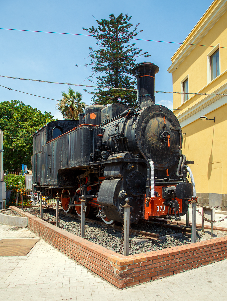 Die FS Schmalspur Zahnrad-Dampflokomotive R.370 012 als Denkmal am Bahnhof Catania Centrale am 20.07.2022.

Die Dampflokomotive R.370 war eine mit Kohle befeuerte dreiachsige Lokomotive, die von den Italienische Staatseisenbahnen (FS - Ferrovie dello Stato Italiane) f�r den Einsatz auf den sizilianischen Schmalspurbahnen mit Zahnstangentrieb beschafft wurden. Die Dampflokomotiven der Gruppe R.370 wurden ab 1909 im Vorfeld auf die Inbetriebnahme der FS Schmalspurbahnen Siziliens von der Costruzioni Meccaniche di Saronno (Zweigwerk der Maschinenfabrik Esslingen) konstruiert und gebaut. Damals wurden die sehr wichtigen Schwefelabbaugebiete der Provinzen Enna, Caltanissetta und Palermo erschlossen.

Sie wurden haupts�chlich auf folgenden Bahnstrecken verwendet:
•	Caltagirone - Piazza Armerina - Dittaino
•	Dittaino – Assoro - Leonforte
•	Agrigento-Naro-Licata
•	Lercara-Filaga-Magazzolo
•	Filaga-Palazzo Adriano

Es wurden insgesamt 48 dieser Dampflokomotiven gebaut. Die R.370 012 wurde 1915 gebaut und war auf der 81 km langen Bahnstrecke Caltagirone - Piazza Armerina – Dittaino, bis zur Einstellung der Strecke 1971, im Einsatz. Seit August 1985 ist sie im Bahnhof Catania Centrale als Denkmal aufgestellt. 

TECHNISCHE DATEN:
Spurweite: 950 mm
Zahnradantrieb: System Strub
L�nge �ber Puffer: 7.678 mm
Achsabst�nde: 1.300 mm / 1.700 mm
Treibraddurchmesser: 950 mm
Dauerleistung: 400 PS
Maximale Zugkraft: 80 t
H�chstgeschwindigkeit: 35 km/h
Gewicht: 37t

