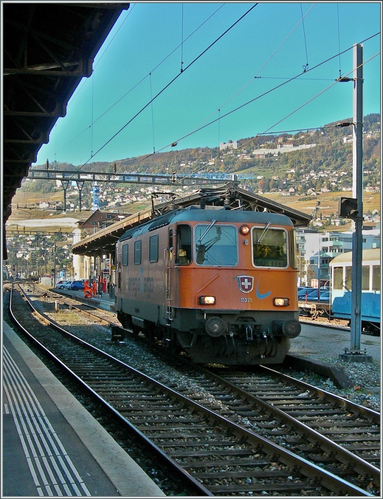 Die im Interregio-Cargo Farbkleid gehaltene Re 4/4 II 11320 in Vevey, links im Bild ein B-C Neuzugang.
12. Nov. 2013