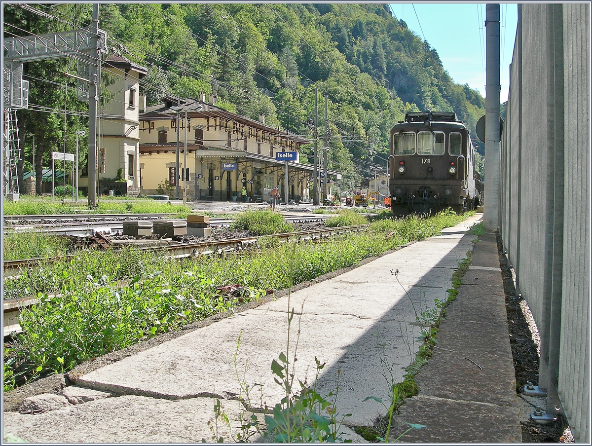 Die kleine Coolpix durch den Zaun gesteckt und schon sieht die Welt bzw. das Bild schon ganz anders aus:  Die BLS Re 4/4 178  Schwarzenburg  ist mit ihrem Tunnelautozug in Iselle eingetroffen, aber es dauert seine Zeit, bis die Lok die Frontlichter für die Rückfahrt zeigt; Das Bild zeigt auch, dass infolge der Baubedingten Streckensperre auch gleich der Bahnsteig 2/3 in Iselle erneuert, wird. Das vereitelte meine Pläne mit etwas Charme von dort auszu einem Bild zu kommen. 

19. August 2020