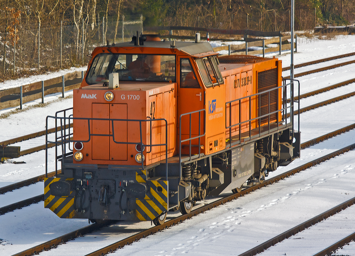 
Die Lok 42 (277 902-3) der KSW (Kreisbahn Siegen-Wittgenstein) eine MaK 1700 BB rangiert am 14.03.2014 auf dem KSW-Rangierbahnhof in Herdorf.
Die Lok ist Vossloh MaK G 1700 BB (eingestellt als 92 80 1277 902-3 D-KSW), sie wurde 2001 unter der Fabriknummer 1001108 bei Vossloh gebaut, und war die erste gebaute G 1700 BB.

Die Vossloh Lokomotive MaK G 1700 BB ist eine dieselhydraulische Lokomotive. Bei der Überarbeitung der Typenpalette nach der Übernahme der MaK durch Vossloh 1998 wurde im 4. Typenprgramm unter der Bezeichnung G 1700 BB der Bau einer vierachsigen Streckenlokomotive mit Mittelführerhaus vorgesehen. Tatsächlich handelte sich zunächst um eine Weiterentwicklung der G 1206. Die Maschine wurde in einigen Details an die Lokomotiven des 4. Typenprgramms angepasst. Dies betraf in erster Linie den Rahmen, der so geändert wurde, dass die neuen Standarddrehgestelle verwendet werden konnten. Dabei wurden die Rahmenenden so umgestaltet, dass die Lokomotiven die im 4. Typenprgramm üblichen Komfortaufstiege erhielten. Ebenfalls geändert wurde der Dieselmotor. Zum Einsatz kam der schon bei den G 1206 für die Dortmunder Eisenbahn verwendete MTU 12V 4000 R20 mit einer unveränderten Leistung von 1500 kW. Die übrigen Komponenten der G 1700 BB blieben gegenüber der G 1206 weitgehend unverändert.

Die ersten beiden Lokomotiven dieses Typs wurden im Jahr 2001 ausgeliefert. Ende 2002 und Anfang 2003 folgten weitere vier Lokomotiven als Vorratsbauten.

Nach diesen sechs Lokomotiven wurde der Bau der G 1700 BB zugunsten der technisch sehr ähnlichen und bereits weiter verbreiteten G 1206 wieder eingestellt.

Bei der G 1700-2 BB handelt es sich nicht um eine Weiteentwicklung der G 1700 BB, sondern um eine komplette Neuentwicklung.

Technische Daten
Spurweite: 1.435 mm
Achsfolge: B´B´
Länge über Puffer: 14.700 mm
Drehzapfenabstand: 7.400 mm
Drehgestellachsstand: 2.400 mm
größte Breite: 3.080 mm
größte Höhe über Schienenoberkante: 4.220 mm
Raddurchmesser neu: 1.000 mm
kleinster befahrbarer Gleisbogen: 60 m
Dienstgewicht 87,3 t
Kraftstoffvorrat 3.500 l

Motor: MTU-12-Zylinder-Dieselmotor, vom Typ 12V4000R20
Leistung: 1.500 kW bei 1800 U/min

Getriebe: Voith L 5r4 zU2
Höchstgeschwindigkeit : 100 km/h

Baujahr 2001 - 2003
gebaute Stückzahl 6