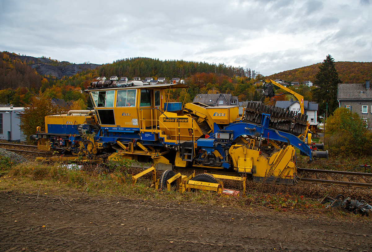 
Die Plasser & Theurer Schotterverteil- und Planiermaschine SSP 110 SW, Schweres Nebenfahrzeug Nr. D-DGU 99 80 9425 068-0, ex 97 16 46 516 18-9 D-DGU (ex Hering Gleisbau, ex Volker-Rail), ist am 27.10.2020 zwischen Neunkirchen und Herdorf auf der Hellertalbahn (KBS 462) im Einsatz. Hier in Herdorf folgt sie im 2. Durchgang der  Plasser & Theurer Universalstopfmaschine UNIMAT 09-475/4S (Kombinierte Gleis- und Weichenstopfmaschine), Schweres Nebenfahrzeug Nr. D-DGU 99 80 9424 001-2. 

Der Schotterpflug wurde 2007 von der Plasser & Theurer unter der Maschinen-Nr. 840 gebaut.