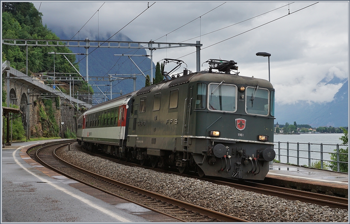 Die Re 4/4 11161 mit dem IR 1714 von Brig nach Genève Aéroport bei der Durchfahrt in Veytaux-Chillon. Dieser Zug wird in der Regel von einer Re 460 mit einem EW IV -Pendel geführt.
13. Juni 2018 