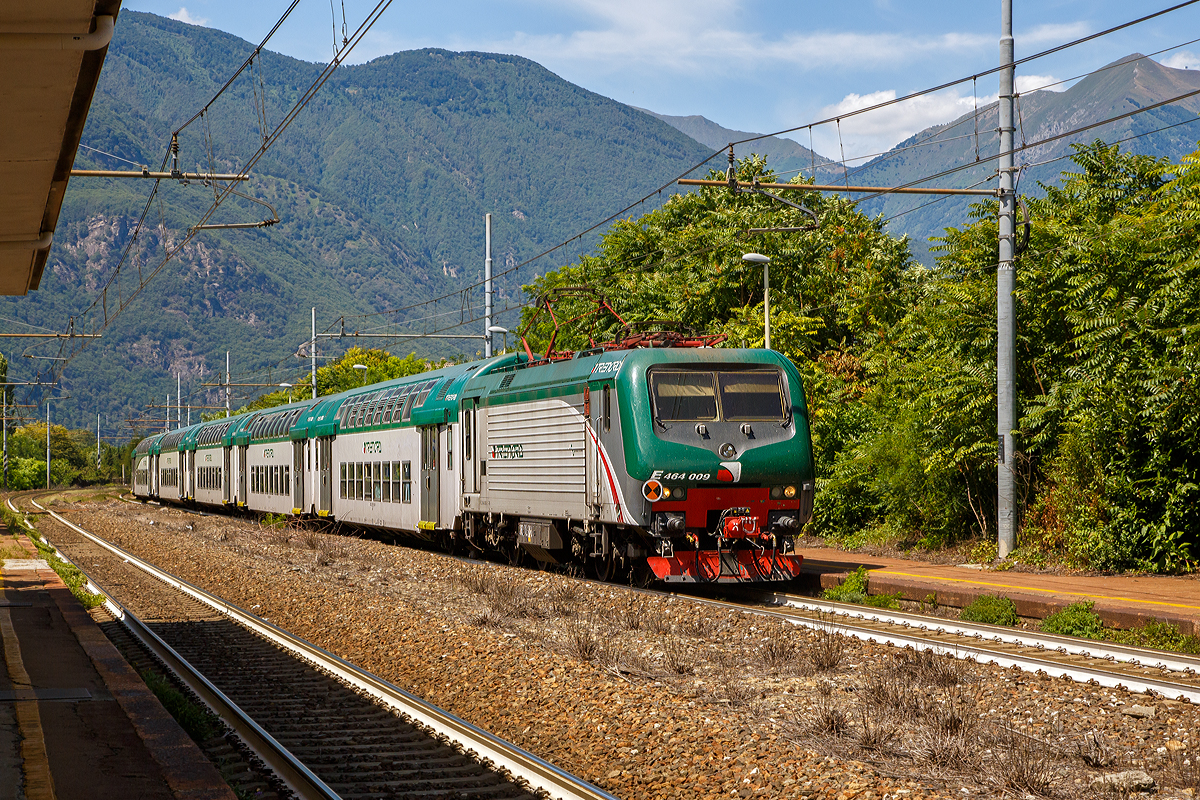
Die rechtsaubere Trenord E.464.009 (91 83 2464 009-2 I-TN), eine Bombardier TRAXX P160 DCP, fährt am 03.08.2019 mit einem RE (Domodossola nach Milano) durch den Bahnhof Vogogna (Stazione Ferroviaria di Vogogna Ossola).