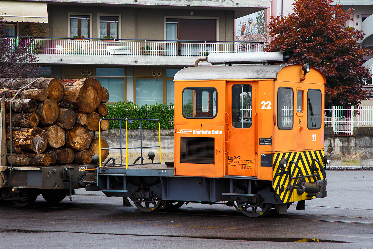 Die RhB Tm 2/2 22, ex RhB Tm 2/2 58, steht am 02.11.2019 mit drei angehangenen und mit Rundholz beladenen Flachwagen vom Typ “Sp-w“ der Serie 8271 – 8300 beim Bahnhof Tirano. 

Der Traktor vom Typ RACO 55 LA 4 wurde 1965 von RACO (Robert Aebi AG) unter der Fabriknummer 1717 gebaut. Im Jahr 1989 erfolgte die Remotorisierung mit einem Cummins Motor vom Typ 4BT 3.9 und die Umzeichnung in Tm 2/2 22.

Als Tm 2/2 werden diesel- oder benzinbetriebene Traktoren (Kleinlokomotiven) bezeichnet.
Die RhB besa� im Laufe der Jahre insgesamt 42 zweiachsige Traktoren mit Verbrennungsmotoren. Davon haben sechs eine Funkfernsteuerung und tragen deshalb die Bezeichnung Tmf 2/2. Die verbleibenden 36 Fahrzeuge teilen sich auf in 26 heute orange Rangierfahrzeuge und 10 heute gelbe Baudiensttraktoren. Insgesamt hatte die RhB 12 dieser baugleichen RACO 55 LA 4.

Zwischen 1957 und 1969 lieferte die Firma Robert Aebi (Raco) die dieselmechanischen Traktoren Tm 2/2 64–67, 62–63, 57–61 und schlie�lich noch Nummer 56. Die Nummerierung erfolgte vor den schon vorhandenen Tm 68 und 69. Basis f�r diese Fahrzeuge waren die Tm II der SBB. Der mechanische Aufbau wurde von RACO entwickelt und gebaut, der Dieselmotor war von Saurer-SLM. Die Kraft�bertragung vom Motor auf die Achsen erfolgte mittels Kettenantrieb, dadurch sind diese Traktoren nur f�r den leichten Verschubdienst an Bahnh�fen geeignet. Bei einem Umbau in den Jahren 1989-90 wurden die Motoren von SLM durch solche von Cummins ausgetauscht, dabei wurden die Nummern auf 15 bis 26 ge�ndert und die Traktoren dabei in die Ablieferungsreihenfolge gebracht. Die urspr�nglich rotbraun, heute orange lackierten Fahrzeuge sind 5,06 m lang und 9 t schwer. Sie bestreiten den Rangierdienst auf Stationen mit kleinem bis mittlerem G�teraufkommen, wobei die meisten der 12 Traktoren ihrer jeweiligen �Heimatstation� fest zugeteilt sind.

TECHNISCHE DATEN:
Spurweite: 1.000 mm
Achsfolge: B
L�nge �ber Puffer: 5.060 mm
Breite: 2.640 mm
Leergewicht: 9 t
Ladegewicht: 2 t
H�chstgeschwindigkeit: 30 km/h (55 km/h Schleppfahrt)
Motorbauart: 4-Zylinder-Dieselmotor
Motortyp: ab 1989/90 Cummins 4BT 3.9 (urspr�nglich Saurer-SLM 4 VD 11)
Motorleistung: 62 kW (urspr�nglich 44 kW)
Anfahrzugkraft: 30 kN (urspr�nglich 25 kN)
Stundenzugkraft: 15 kN bei 10 km/h
Leistungs�bertragung: Rollenkette

Leider auch schon historisch: Dieser Rangiertraktor wurde im Februar 2021 abgebrochen. Alle RACO (55 LA 4) Rangiertraktor Tm 2/2 15 bis 26 wurden von der RhB ausrangiert und verkauft bzw. abgebrochen.