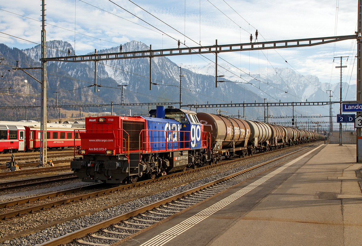 
Die SBB Cargo Am 843 073-8 (eine modifizierte Vossloh MaK 1700) fährt am 20.02.2017 mit einem langen Kesselwagenzug (Wagen der Gattung Zans, laut Warntafel 30/1202 für/mit Heizöl / Dieselkraftstoff) in den Bahnhof Landquart, wo der Zug später von einer Re 4/4 II übernommen wird.


Die Lok wurde 2004 von Vossloh in Kiel unter der Fabriknummer 1001421 gebaut und an die SBB Cargo AG in Basel geliefert. 

Die SBB Am 843 ist eine moderne Rangier- und Güterzugslokomotive der Schweizerischen Bundesbahnen (SBB). Sie ersetzt ältere Rangierlokomotiven wie die SBB Bm 4/4 und SBB Bm 6/6. Eingesetzt wird die Am 843 von der Division Infrastruktur (843 001ff), der Division Personenverkehr (041ff) und von SBB Cargo (050ff). Die Division Infrastruktur verwendet die Am 843 vor allem in den großen Rangierbahnhöfen, Personenverkehr in Basel und Chiasso und bei SBB Cargo dient sie vor allem für Zustellfahrten im Nahgüterverkehr.

Die Am 843 verfügt über einen Mikropartikelfilter und gilt als eine der saubersten Diesellokomotiven. Die Filteranlage verhindert, dass 95 % der Russpartikel in die Umwelt abgegeben werden. Die Am 843 basiert auf den dieselhydraulischen Standardlokomotiven des Typs G 1700-2 BB des Kieler Schienenfahrzeugherstellers Vossloh, ist aber im Gegensatz zur Standard-Version auf den in der Schweiz üblichen Linksverkehr ausgelegt.

Anfang der 2000ter musste eine neue Lokomotive angeschafft werden, welche allen Anforderungen gerecht wurde. So musste die Lok über hervorragende Langsam Fahreigenschaften verfügen um im Verschubdienst eingesetzt werden zu können. Die SBB-Cargo wollte aber auch im Nahbereich Zustellfahrten machen, was eine Höchstgeschwindigkeit von 100 km/h erfordernde und gute Leistung. Schließlich fiel die Wahl auf die MaK 1700 BB, welches bei Vossloh in Kiel entstehen sollte. Vossloh entstand aus der ehemaligen und bekannten Unternehmen Maschinenfabrik Kiel (MaK). Dies war die erste größere Serie die der Kieler Lokomotivbau in die Schweiz verkaufen konnte. Noch bei der letzten Ausschreibung haben die Kieler gegen das Konsortium um Alstom verloren. Ebenfalls eine Neuheit war, dass die SBB erstmals eine größere Anzahl dieselhydraulischer Lokomotiven anschafften, nachdem bei der Am 841 noch einer dieselelektrischen Lokomotive der Vorzug gewährt wurde.

Der Lokrahmen besteht aus Walzträgern und massiven Blechen, welche in Schweißkonstruktion miteinander verbunden wurden. Dadurch entsteht ein stabiler und robuster Grundaufbau, welcher der Lok die notwendigen Festigkeiten verleiht. Im Lokrahmen wurde eine so genannte Umweltwanne montiert, welche aus dem Fahrmotor austretenden Flüssigkeiten (Mineralölen und Wasseremulsionen) auffängt, diese können mit Hilfe eines Ablasshahnes entleert und fachmännisch entsorgt werden.

Der vordere längere Vorbau beinhaltet neben dem Dieselmotor auch die notwendige Kühlanlage und das Antriebsgetriebe. Der kürzere hintere Vorbau enthält neben der Druckluftanlage auch die elektrischen Komponenten wie die Batterieladung.

Zwischen den beiden Vorbauten befindet sich das Mittelführerhaus, welches über die zwei diagonal gegenüberliegenden Eingangstüren betreten werden kann. In ihm sind alle für den Lokführer notwendigen Einbauten vorhanden. Ein Führersitz je Fahrpult und Fahrrichtung, welcher mit Arm- und Rückenlehnen ausgerüstet ist, erlaubt die sitzende Bedienung der Lokomotive. Dieser Führersitz ist drehbar gelagert und kann zusammengeklappt und unter den Führertisch verschoben werden. Dadurch ist auch die stehende Bedienung der Lokomotive ohne Behinderung möglich. Zur Entlastung der Füße sind auch verstellbare Fußstützen montiert. Der Fußboden ist mit einem Profilgummibelag belegt worden, der eine einfache Reinigung und dennoch einen guten Stand erlaubt.

Angetrieben wird die Lokomotive von einem 12-Zylinder-4Takt-Dieselmotor vom Typ Caterpillar 3512 B DI-TA-SCAC, dieser erbringt mit Hilfe der beiden Abgasturbolader und der Ladeluftkühlung eine maximale Leistung von 1.500 KW (2.040 PS). Seine höchste Drehzahl beträgt 1.800 U/min. Er wird mit Hilfe eines elektrischen Anlassers gestartet und ist elektronisch geregelt. Dadurch ist es möglich, den Motor bestmöglich im optimalen Leistungsbereich zu betreiben. Sein Gewicht beträgt mit 322 Liter Schmieröl und 134 Liter Kühlwasser 7.700 kg.

Die vom Dieselmotor erzeugte Leistung wird mittels einer Gelenkwelle auf das hydrodynamische Getriebe (Turbowendegetriebe), vom Typ Voith L5r4zseU2, übertragen. Das Getriebe hat eine maximale Leistung von 1.400 kW. Es beschränkt somit die Leistung der Lokomotive und verhindert zugleich, dass der Fahrmotor überlastet werden kann. Seine maximale Drehzahl ist gleich groß, wie jene des Fahrmotors. 

Das Turbowendegetriebe besitzt für jede Fahrrichtung zwei Drehmomentwandler. Dem eigentlichen Wandlergetriebe ist eine mechanische Getriebe nachgeschaltet, das eine niedrige für den Rangierbetrieb bestimmte Schaltung und eine höhere für den Streckenbetrieb bestimmte Schaltung zur Verfügung zu stellen. Diese Umschaltung darf jedoch erst im Stillstand erfolgen.

Die Achsen in den Drehgestellen werden über Gelenkwellen vom Turbowendegetriebe angetrieben. Die Übertragung auf die Achsen erfolgt mit Hilfe von Stirnradgetrieben mit Kegelradvorgelege.

Technische Daten:
Spurweite: 1.435 mm (Normalspur)
Achsformel: B'B'
Länge über Puffer: 15.200 mm
Höhe: 4.220 mm
Breite: 3.080 mm
Drehzapfenabstand: 7.700 mm
Achsstand im Drehgestell: 2.400 mm
Dienstgewicht:  80 t
Höchstgeschwindigkeit: 100 km/h (40 km im Rangiergang)
Installierte Leistung: 1.500 kW (2.040 PS)
Anfahrzugkraft:  249 kN
Treibraddurchmesser:  1.000 mm
Motorentyp:  Caterpillar 3512B DI-TA-SCAC
Nenndrehzahl: 1.800/min
Kleinster bef. Halbmesser:  60 m
Tankinhalt: 3.500 l