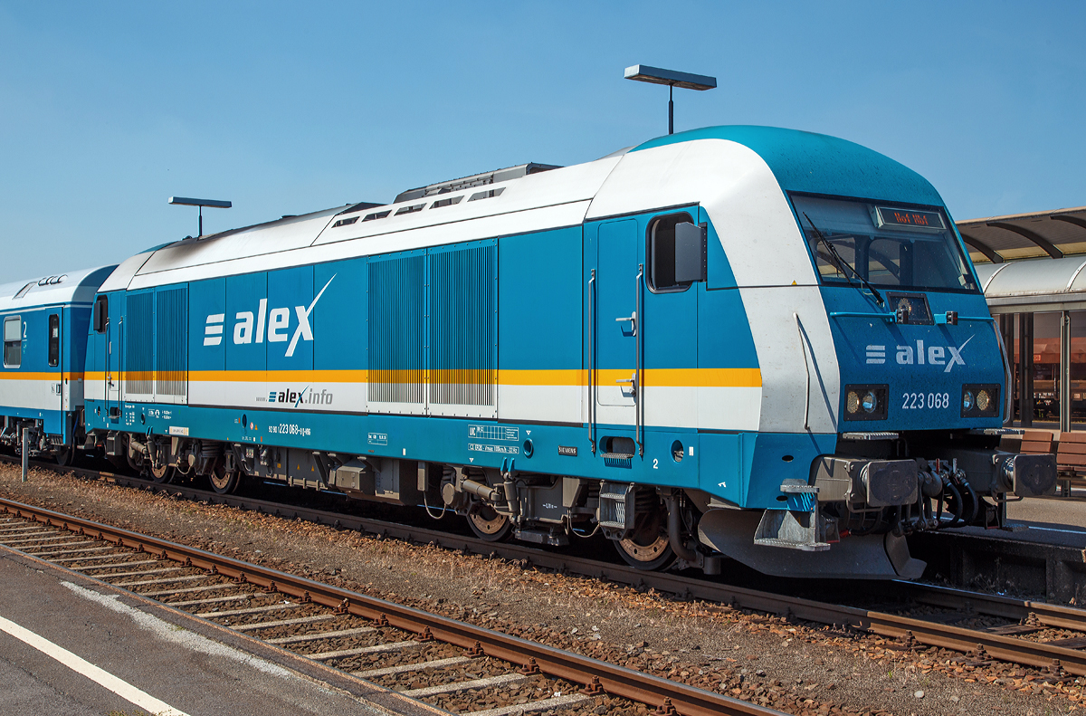 Die Siemens ER 20 ( Herkules  223 068-8 (92 80 1223 068-8 D-VBG) am 01.07.2015 beim Halt, mit dem ALX 84110  (alex) M�nchen Hbf - Hof Hbf, im Bahnhof Marktredwitz. 

Die Siemens Eurorunner 20 wurde 2007 von Siemens unter der Fabriknummer 21456, sie ist Eigentum der Alpha Trains NV/SA, Antwerpen und ist an die Vogtlandbahn vermietet. 

Der alex ist eine von der Vogtlandbahn betriebene Zuggattung des Schienenpersonennahverkehrs in Bayern. Bis 2010 lautete die offizielle Bezeichnung Arriva-L�nderbahn-Express. Die Vogtlandbahn GmbH (VBG) ist ein deutsches Eisenbahnverkehrsunternehmen mit Sitz in Neumark (Sachsen), das urspr�nglich nur im Vogtland Verkehrsleistungen erbrachte, mittlerweile aber auch �berregional agiert. Die Vogtlandbahn ist ein Unternehmen der „Regentalbahn – Die L�nderbahn“ welche zur Ferrovie dello Stato-Tochterfirma Netinera (ehemals Arriva Deutschland) geh�rt.