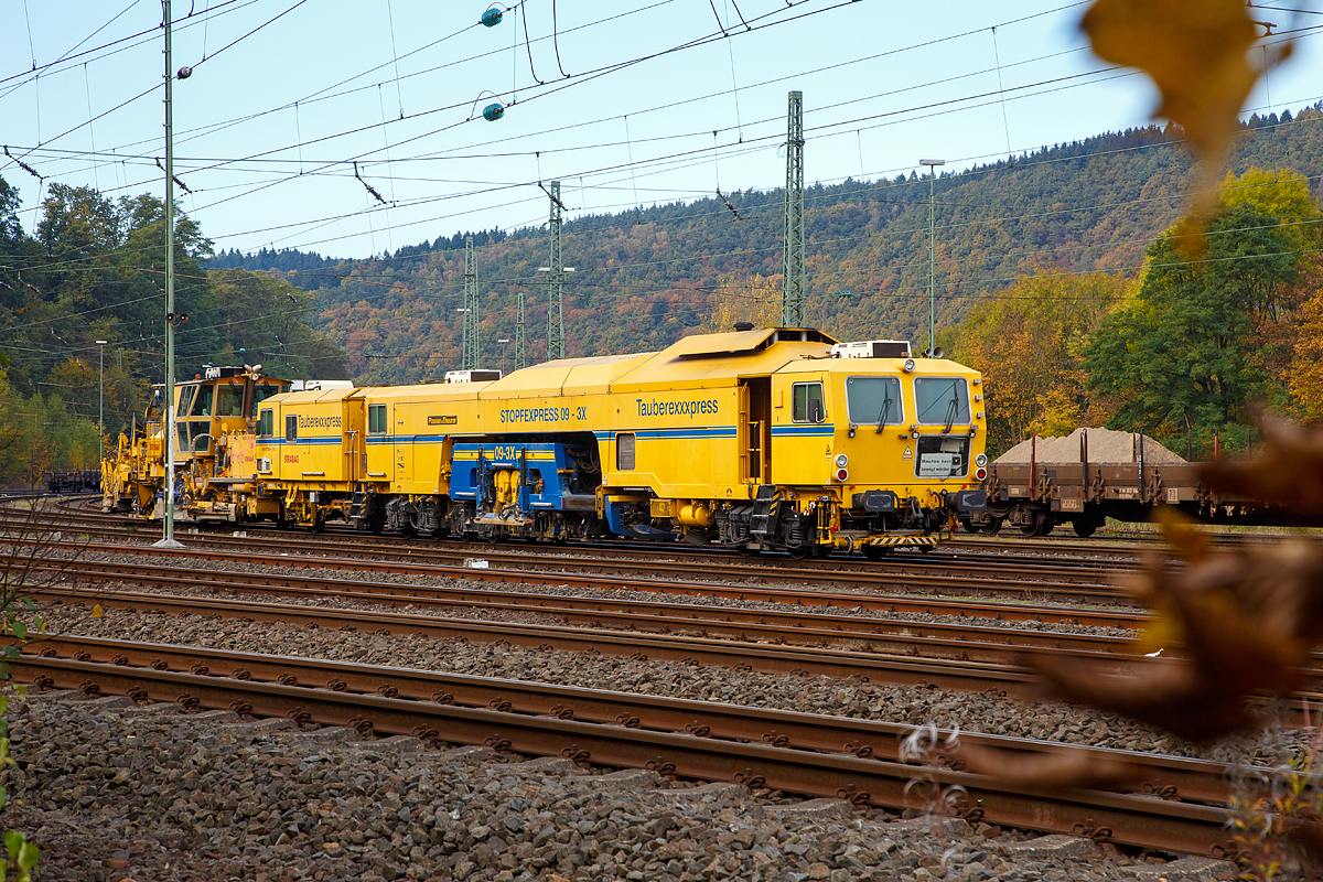 
Die STRABAG Tauberexxpress eine Plasser & Theurer Stopfexpress CSM 09 – 3X (PL) (Gleisstopfmaschine), Schweres Nebenfahrzeug Nr. 99 80 9121 004-2 D-BRS, der BMTI Rail Service GmbH (Servicebetrieb der STRABAG SE), abgestellt am 23.10.2016 in Betzdorf/Sieg.

Ausrüstung:
- Proportional-Parallel-Nivelliersystem
- Einsehnen: 3-Punkt-Richtsystem mit Lasersteuerung
- kombinierter Höhen-Richtlaser (KHR)
- automatischer Leitcomputer ALC mit zusätzlichen USB-Anschluss, WIN-Version, Disketten- und CD-Laufwerke
- Datenverarbeitung aller EM-SAT Daten möglich
- digitaler 8-Kanal-Schreiber, inkl. Rec-Funktion, DAR-Graph und DAR-Control (Software zum Bedienen und Anzeigen des MKS und dessen Daten)
- Mephisto Laser-Fixpunkt-Messgerät
- Vorkopfverdichter zum Verdichten der Bettungsschulter
- schallisolierte Bedienerkabine
- 2 x Dreischwellen-Stopfaggregate, Stopfleistung bis 2.200 m /h möglich
- Laserwagen zur Aufnahme des Lasersenders, selbst fahrend und mit integriertem Wegmessrad
- hochverschleißfeste Stopfpickel
- polnische Sicherheitsausrüstung für Eigenfahrt bei PKP

Technische Daten:
Hersteller:  Plasser & Theurer
Baujahr: 2001
VDM-Nr.: 99 80 9121 004-2 D-BRS

Motor: wassergekühlter Caterpillar E3412 E/DITA 12-Zylinder -Dieselmotor
Drehzahl: 2.100 U/min
Leistung: 704 kW
max. Geschwindigkeit in Eigenfahrt: 100 km/h
max. Geschwindigkeit in Schleppfahrt: 100 km/h
Eigenfahrtrichtung: beidseitig
Achsanzahl: 7
Sifa/PZB/ Zugbahnfunk (analog / digital): ja    
Arbeitsgeschwindigkeit: bis zu 2.200 m/h
Arbeitsweise:  drei. oder einschwellig
min. Radius bei Arbeit: 200 m
min. Radius bei Fahrt: 150 m

Fahrzeug: 
Zulassung: gemäß Richtlinien EBA/DB AG §32
Spurweite: 1.435  mm
Eigengewicht: 100,0  t
Höhe: 3.900  mm
Breite: 3.000  mm
Länge über Puffer:  29.900 mm

Dahinter steht die P&T Schnell-Schotterverteil- und Planiermaschine SSP 110 SW, Schweres Nebenfahrzeug Nr. 99 80 9425 014-4 D-STRA.
