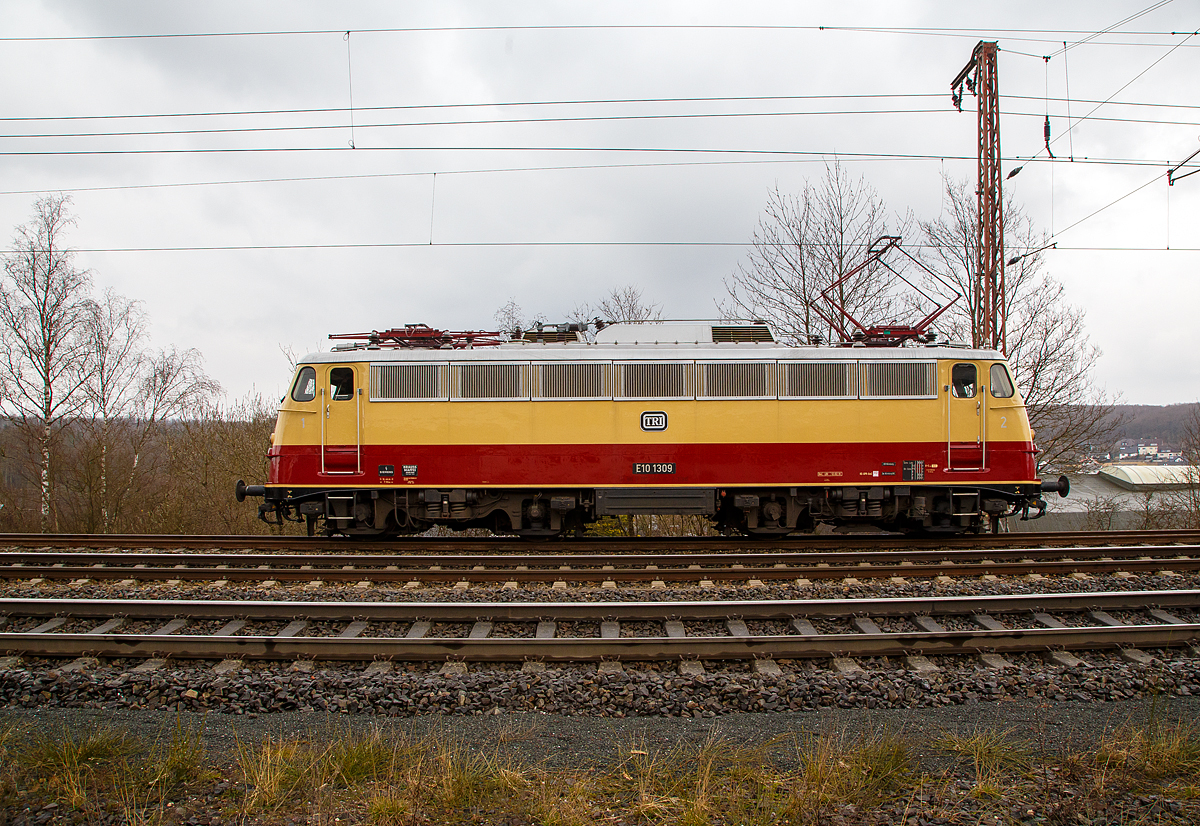 Die TRI E10 1309 (91 80 6113 309-9 D-TRAIN) der Train Rental International GmbH hat am 18.03.2021 als Lokzug in Rudersdorf (Kr. Siegen), an der Dillstrecke (KBS 445), Hp 0. Sie muss erst einen Güterzug überholen lassen.

Die Lok, eine sogenannte „Bügelfalten“ E10.12 mit Henschel-Schnellfahrdrehgestellen für dem TEE Rheingold bzw. TEE Rheinpfeil, wurde 1963 von Krauss-Maffei in München-Allach unter der Fabriknummer 19014 gebaut (der elektrische Teil ist von Siemens) und an die Deutschen Bundesbahn als E10 1309 geliefert. Mit der Einführung des EDV-gerechte Nummernsystems erfolgte zum 01.01.1968 die Umzeichnung in DB 112 309-0. Nach der deutschen Wiedervereinigung und dem darauffolgenden Vereinigung der beiden deutschen Staatsbahnen (DB und DR) wurde sie zum 01.01.1991 in DB 113 309-9 umgezeichnet und fuhr so bis zur Ausmusterung und Verkauf im Jahr 2014.

TECHNISCHE DATEN:
Spurweite: 1.435 mm
Achsformel: Bo’Bo’
Länge über Puffer: 16.440 mm
Drehzapfenabstand:  7.900 mm
Achsabstand im Drehgestell:  3.400 mm
Dienstgewicht: 85,0 t
Höchstgeschwindigkeit: 160 (zeitweise 120 km/h)
Stundenleistung: 3.700 kW (kurzzeitig bis 6.000 kW)
Dauerleistung: 3.620 kW
Anfahrzugkraft: 275 kN
Treibraddurchmesser: 1.250 mm
Stromsystem:  15 kV 16 ⅔ Hz ~
Anzahl der Fahrmotoren: 4
Antrieb: Gummiringfeder
Bremse: mehrlösige Knorr-Einheits-Druckluftbremse, Zusatzbremse, fremderregte elektrische Widerstandsbremse (max. Bremsleistung 2.000 kW, Dauerleistung 1.200 kW)