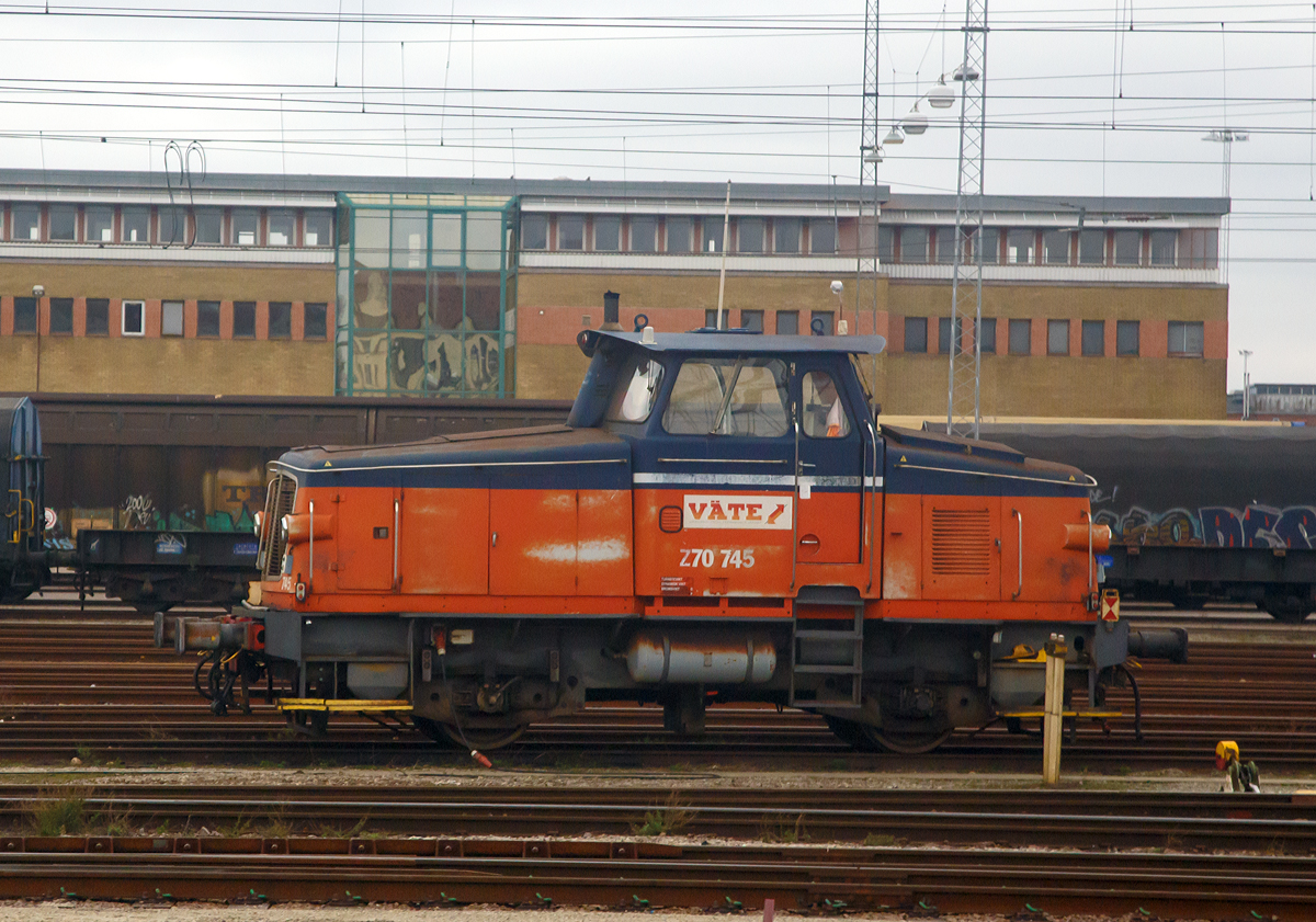 
Die V�te Z70 745, ex GC Z70 745, ex SJ Z65 589, stand am 22.03.2019 im Rangierbahnhof Malm� und wartet auf ihren n�chsten Einsatz. (Fotografiert aus dem Zug).

Die Lok wurde 1967 als Z65 589 von Kalmar Verkstad AB unter der Fabriknummer 344 gebaut und an die SJ (Statens J�rnv�gar, der ehemaligen schwedischen Staatsbahnen) geliefert. In den fr�hen 1990er Jahren beschlossen die SJ, eine Reihe Z65 zu modernisieren. So wurde 1992 die Z65 589 von Kalmar Verkstad AB zur Z70 745  modernisiert.

Die Baureihe Z70 sind eine Serie von schwedischen dieselhydraulischen Kleindiesellokomotiven, die aus modernisierten Lokomotiven der Baureihe Z65 hervorgingen. Die Lokomotiven wurden mit neuen Scania DSI-1447 Motoren (f�r die bislang vorhandenen Rolls-Royce-Motoren) und Fernsteuerung ausger�stet. Um den gr��eren Motor unterzubringen, musste das Lokgeh�use erh�ht werden. Daran k�nnen die umgebauten Lokomotiven sicher erkannt werden, zudem erhielten sie neue Seriennummern.

TECHNISCHE DATEN:
Anzahl: 50 (Umbau aus Z65)
Spurweite: 	1.435 mm (Normalspur)
Achsformel: B
L�nge �ber Kupplung: 9.360 mm
Dienstgewicht: 34 t
H�chstgeschwindigkeit: 70 km/h
Leistung: 333 kW (446 PS)
Anfahrzugkraft: 102 kN
Treibraddurchmesser: 	985 mm
Motorentyp: Scania DSI-1447
Leistungs�bertragung: Hydraulisch
