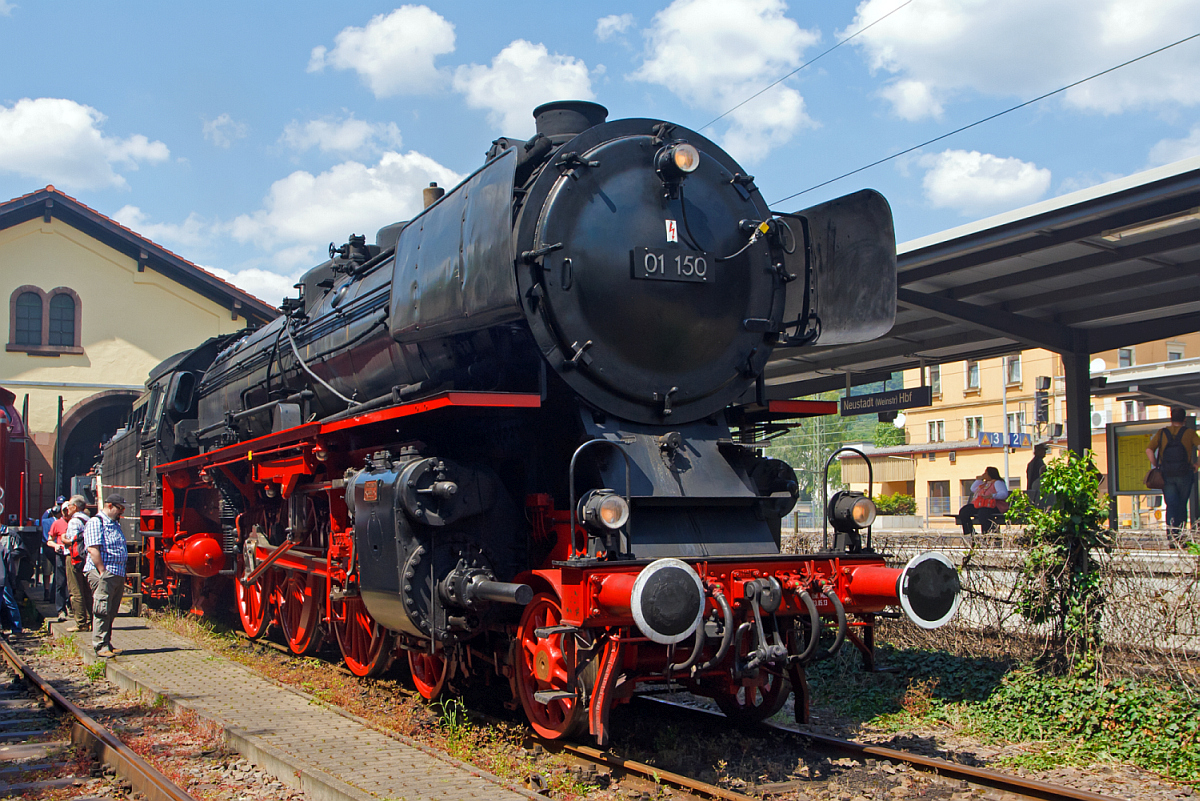 Die Zweizylinder-Heißdampf-Schnellzuglokomotive DB 01 150, ex DB 001 150-2, ist leider aufgrund eines Laufwerkschadens, beim Dampfspektakel 2014, nicht zum Einsatz gekommen. So stand sie warm abgestellt am 30.05.2014 im Eisenbahnmuseum Neustadt an der Weinstraße (Pfalzbahn - Museum).

01 150 wurde 1935 von Henschel in Kassel mit der Fabriknummer 22698 gebaut und an die DR geliefert. Sie zählt nicht zu den 50 Loks, die ab 1957 auf neue geschweißte Hochleistungskessel umgerüstet wurden, sondern noch den vollständig genietete Altbaukessel.

Bis zur Ausmusterung bei der DB 1973 war zuletzt in Hof beheimatet. 01 150 war bei den beiden großen Jubiläumsparaden (100 und 150 Jahre Deutsche Eisenbahn) dabei, 1935 als fabrikneue Lok und als Museumslok 1985, nach dem sie von der DB wieder aus Privathand zurück gekauft worden war. Sie befindet sich im Besitz der DB AG und wird vom DB Museum Nürnberg betreut. Sie wurde beim Großbrand des Depots in Nürnberg am 18.10.2005 schwer beschädigt.

Seit August 2012 gehört auch die 01 150 nach der Kesselneuzulassung durch das EBA wieder zum betriebsfähigen Museumslokbestand der DB AG. Sie ist vom DLW Meiningen bis September 2011 komplett aufgearbeitet worden und wurde zunächst der Öffentlichkeit als rollfähiges Exponat in Göppingen präsentiert. Eine optische Änderung erkannte man sofort, sie hatte auf Wunsch des Sponsors Märklin zu Marketingzwecken des nachgebildeten Modells große Windleitbleche (Bauart Wagner) und eine breite Frontschürze bekommen. 

Auf Grund erheblicher Verschleißerscheinungen wurde der nicht mehr aufarbeitungsfähige noch vollständig genietete Altbaukessel gegen einen in Meiningen gefertigten modernen geschweißten Nachbaukessel ersetzt, wodurch sich die Inbetriebnahme-Genehmigung des Eisenbahn-Bundesamtes bis August 2012 verzögerte. Seit September 2012 sind, sowohl die Wagner-Windleitbleche durch das DLW Meinigen gegen die kleineren Witte-Windleitbleche ausgetauscht, als auch die breite Frontschürze zurückgebaut worden, sodass sie nun dem letzten Betriebszustand der Bundesbahnära vor ihrer Ausmusterung entspricht. 

Am 23. Mai 2013 wurde sie bei einem Festakt im Beisein der Eigentümerin übergeben. Nach Angaben der Deutschen Bahn AG wird 01 150 zukünftig im SEH Heilbronn beheimatet und von der Eisenbahnstiftung Joachim Schmidt im Auftrag des Verkehrsmuseums Nürnberg betreut und betrieben. 

Die Aufarbeitung der zerstörten Lokomotive hat nach Auskunft der DB AG insgesamt rund 1.000.000 Euro gekostet, dabei wurden alleine durch Olaf Teubert in zwei Jahren 500.000 Euro an Spendengeldern zur Rettung der Lokomotive eingesammelt.

Sie hat die NVR-Nummer 90 80 0001 150-6 D-EJS.

TECHNISCHE DATEN der 01 150:
Bauart:  2’C1’ h2
Gattung:  S 36.20
Spurweite:  1.435 mm (Normalspur)
Länge über Puffer:  23.940 mm
Höhe:  4.550 mm
Dienstgewicht:  111,1 t (ohne Tender)
Leergewicht Lok und Tender: 169 t Dienstgewicht Lok und Tender: 199 t
Radsatzfahrmasse:  20,2 t
Höchstgeschwindigkeit:  vorwärts 130 km/h / 80 km/h 
Indizierte Leistung:  1.648 kW (ca. 2.240 PS)
Kuppelraddurchmesser:  2.000 mm
Treibraddurchmesser:  2.000 mm
Laufraddurchmesser vorn: 1.000 mm 
Laufraddurchmesser hinten:  1.250 mm
Steuerungsart:  Heusingersteuerung mit Hängeeisen
Zylinderdurchmesser:  600 mm 
Kolbenhub:  660 mm
Kesselüberdruck:  16 bar
Anzahl der Heizrohre:  107 
Anzahl der Rauchrohre:  70 
Heizrohrlänge:  6.800 mm
Rostfläche:  4,32 m²
Tender:  2' 2 T 34
Wasservorrat: 34,0 m³
Brennstoffvorrat:  10,0 t Steinkohle
