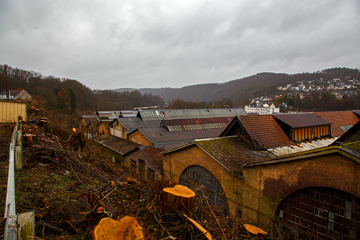Diesen Blick (hier am 20.02.2022) auf das ehemalige AW Betzdorf (Sieg), zu Reichsbahnzeiten auch Eisenbahnausbesserungswerk (EAW), wird es wohl nicht mehr lange geben. Wobei dieser Blick erst seit kurzem möglich ist, da nun hier die Bäume abgeholzt sind.

In den letzten Jahren waren die Hallen noch an einen großen Büromöbel und Lagerkästen Hersteller der Region vermietet. Bald soll es noch Plänen der Stadt, zu Betzdorfs neuen Mittelpunkt der Stadt werden. Auf dem ca. 10.000 m² großen Areal sollen Wohnungen, Einkaufmöglichkeiten und Arbeitsplätze entstehen. So steht wohl bald diesen Gebäuden auch der Abriss bevor. Hier am 18.01.2022 waren son die ersten Vermessungen im Gange. Der ehemalige Ringlokschuppen wurde bereits 2013/14 abgebroch.