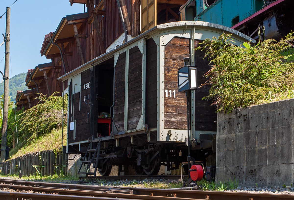 Dieser schmalspurige zweiachsige Gedeckte Güterwagen K 111 diente der Museumsbahn Blonay–Chamby gegenüber der Bekohlungsanlage des Museums in Chaulin als Materiallager (hier am 27.05.2012). 

Er wurde 1886 Baume & Merpent für die Chemin de fer Yverdon–Ste-Croix (YSteC), eine schmalspurige Privatbahn im Kanton Waadt, gebaut. Die Strecke führt von Yverdon-les-Bains am Südende des Neuenburgersees nach Ste-Croix im Waadtländer Jura. Sie ist Teil des regionalen Verkehrsunternehmens Travys.

Leider ist der Wagen im Winter 2014 nach Brand verschrottet worden.
