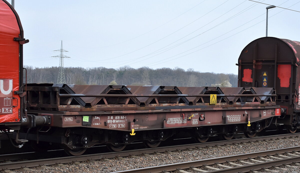 Drehgestell-Flachwagen mit sechs Radsätzen, ohne Seiten- und Stirnwände, mit und ohne Rungen mit Lademulden für Coils der DB Cargo, der Wagen trägt die Nr. 31 RIV 80 D-DB 4838 040-2 Sahlmmps 706.1 in einem gemischten Güterzug am 24.03.26 Höhe Bahnhof Rodleben.