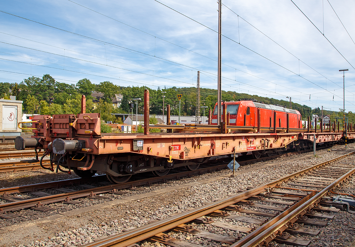 Drehgestellflachwagen mit sechs Rads�tzen, mit Rungen, Stirnwandklappen und klappbaren Ladeschwellen, jedoch ohne Seitenwandklappen, der Gattung Samms 489, (31 80 4852 552-7 D-DB) am 12.08.2018 abgestellt in Kreuztal. 

Zusammen mit Stahlkunden entwickelt DB Schenker im Jahre 2007 einen neuen Flachwagen, der auf die Bed�rfnisse der Branche noch besser eingeht. Gebaut wurden sie von dem slowakischen Hersteller Tatravagonka a.s. Poprad, dieser 2009 unter der Fabriknummer 553.

Der Wagen dient mit aufgeklappten Ladeschwellen zur Bef�rderung von schweren Walzprofilen und anderen sperrigen G�tern. Mit eingeklappten Ladeschwellen, also mit ebener Ladeebene, eignet er sich auch zum Transport schwerer Kettenfahrzeuge. F�r das Be- und Entladen solcher Fahrzeuge sind befahrbare Stirnwandklappen vorhanden.
Die Wagenbr�cke ist eine in Rahmenbauweise ausgef�hrte Schwei�konstruktion, deren Hauptbauteile aus S355J2 (St 52) bestehen. Die Hauptbelastungen werden von den �u�eren Langtr�gern aufgenommen. Das Kopfst�ck und Untergestell sind so ausgebildet, dass sp�ter ohne gro�e �nderungen die AK eingebaut werden kann.
Der Fu�boden besteht aus Kiefernbohlen mit den Abmessungen 70 x 200 mm; er kann eine Radlast von 5,0 t aufnehmen. Im Fu�boden sind 6 geteilte klappbare Ladeschwellen eingebaut, ebenso 6 Zurrpunkte je L�ngsseite. An den Au�enlangtr�gern sind 26 Binde�sen angebracht.

Das Fahrzeug hat auf jeder L�ngsseite 6 Einsteckrungen und 6 zus�tzliche Rungensch�chte, wodurch eine variable Platzierung der Rungen erm�glicht wird (anders als bei den Vorg�nger-Modellen). An jeder Stirnseite gibt es je 2 versenkbare Rungen (Fallrungen). Die Stirnw�nde sind umklappbar.

Die Tragf�higkeit konnte im Vergleich zu anderen Wagen der Bauart Samms auf 105,5 Tonnen gesteigert werden, weshalb bis zu 20 Prozent Wagenresourcen eingespart und die Transportkette optimiert werden kann. Durch den Einsatz der Kunststoff-Bremssohle (Cosind 810) f�hrt der Wagen l�rmreduziert.

TECHNISCHE DATEN:
Gattung: Samms 489 (Gattungskennzahl 4852)
Spurweite: 1.435 mm (Normalspur)
L�nge �ber Puffer: 	16.400 mm
Drehzapfenabstand: 9.150 mm
Radsatzstand in den Drehgestellen: 2 x 1.700 mm = 3.400 mm
Raddurchmesser: 920 mm (neu) 
Drehgestell-Typ: BA 714.3
Ladel�nge: 15.000 	mm
Ladebreite: 2.630 mm (zwischen den Rungen)
Fu�bodenh�he �ber SO: 1.300 mm
Ladefl�che:  46 m�
Eigengewicht: 29.400 kg 
Zuladung bei Lastgrenze S: 75,5 t (ab Streckenklasse D) 
Streckenklasse CE bei max.100 km/h:  90,5 t 
Max. Zuladung: 105,5 t
Max. Geschwindigkeit: 120 km/h
Kleinster Gleisbogenhalbmesser:	75 m
Bauart der Bremse: KE-GP-A (max. 88 t)
Verwendungsf�higkeit: TEN-GE
