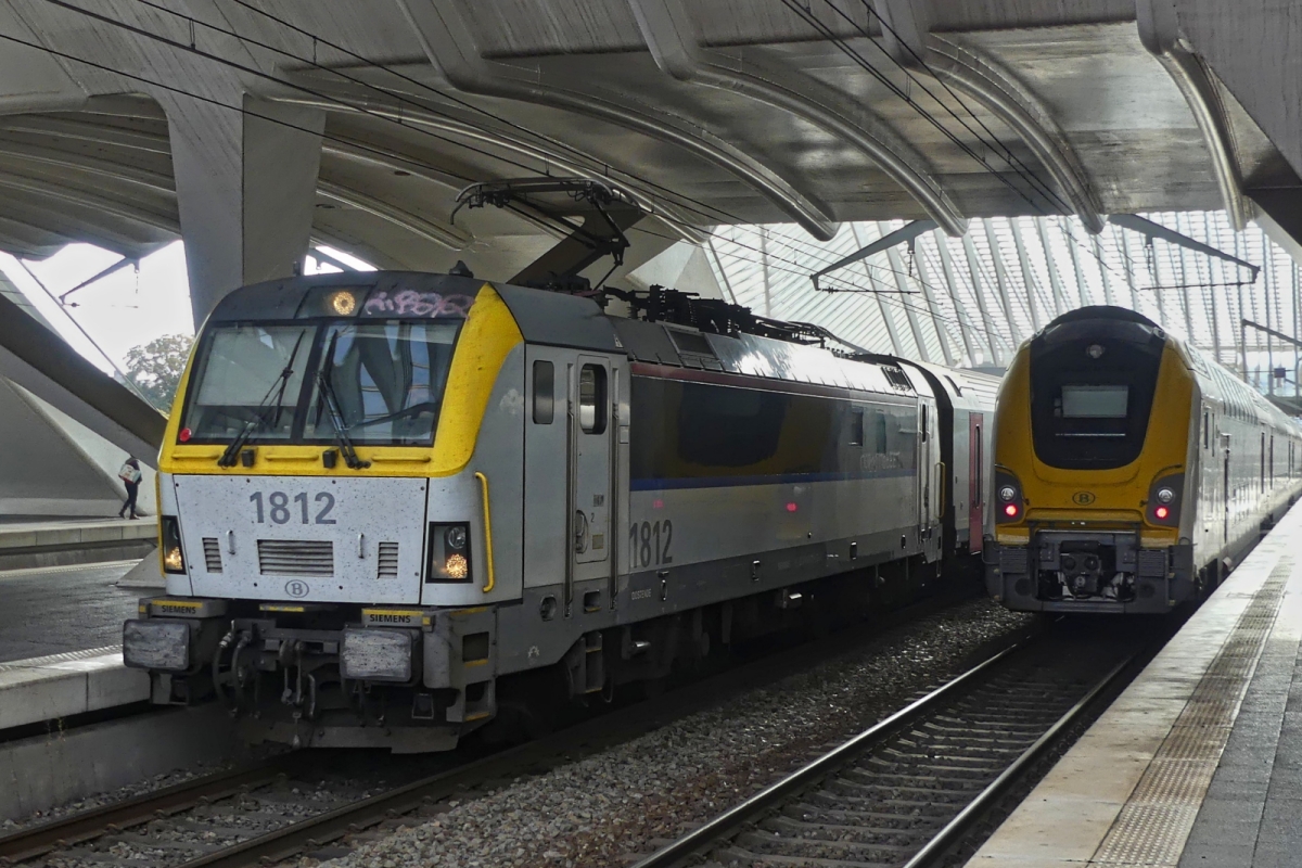 E-Lok 1812 ist mit ihrem Zug in den Bahnhof von L�ttich eingefahren, daneben steht ein M7 Triebzug. 10.07.2025