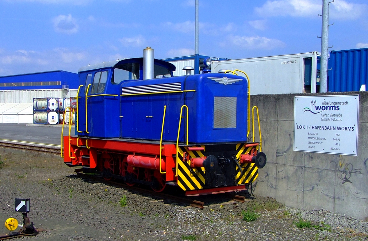 
Ehemalige Lok 1 der Hafenbahn Worms (Denkmallok), am 25.04.2009 in Worms. 

Die Lok ist eine Krauss-Maffei ML440C, sie wurde 1955 unter der Fabriknummer 18156 gebaut und an die Stadtwerke Worms bzw. Hafenbahn Worms geliefert, sie war die erste Diesellok der Hafenbahn.

Die ML 440 C ist eine dieselhydraulische, dreiachsige Steifrahmen-Lokomotive mit Endführerhaus. Die Kraftanlage besteht aus dem aufgeladenen MAN-Dieselmotor W8V 17,5A mit 440 PS (324 kW) Leistung, der über eine elastische Kupplung das Flüssigkeitsgetriebe Voith L 37V antreibt. Diesem Getriebe ist ein Kegelrad - Wendegetriebe nachgeschaltet, dem das Stufengetriebe folgt. Von dessen Stufenzahn-rädern aus erfolgt die Kraftübertragung mittels Stirnradvorgelege auf die Blindwelle, die ihrerseits über Treib- und Kuppelstangen die Achsen antreibt.

Die Lokomotiven des Typs ML 440 C waren konstruktiv ähnlich aufgebaute Wehrmachtslokomotive WR 360 C 14 (bekannt als V 36), sozusagen als bayerische Version der V 36. Krauss-Maffei hatte zwar nie WR-Diesellokomotiven gebaut, jedoch nach dem Krieg WR - Lok - erfahrene Konstrukteure ins Münchner Werk geholt. Zudem war es KM gelungen, über die MaK Kiel an komplette Zeichnungssätze der Wehrmachtslokomotiven zu kommen, die als basierende Konstruktionsunterlagen unverkennbare Einflüsse auf die Entwicklung der ML 440 C hatten.


TECHNISCHE DATEN:

Gebaute Anzahl:  53
Baujahre:  1954ဓ66
Achsformel:  C
Spurweite:  1.435 mm (Normalspur)
Länge über Puffer:  8.700 mm
Höhe:  4.190 mm
Breite:  3.100 mm
Fester Radstand:  3.000 mm
Kleinster bef. Halbmesser:  50 m
Dienstmasse:  48 t
Radsatzfahrmasse:  16 t
Höchstgeschwindigkeit:  28 km/h im Rangiergang / 55 km/h im Streckengang
Installierte Leistung:  440 PS bei 1.100/min
Treibraddurchmesser:  1.006/mm
Motorentyp:  MAN W 8 V 17,5/22 A
Motorbauart:  8 Zylinder-Viertakt-Reihenmotor mit Abgasturbolader
Leistungsübertragung:  hydraulisch (Voith-Turbo-Getriebe L 37 v)
Tankinhalt:  1.300 l
Lokbremse:  Druckluftbremse

