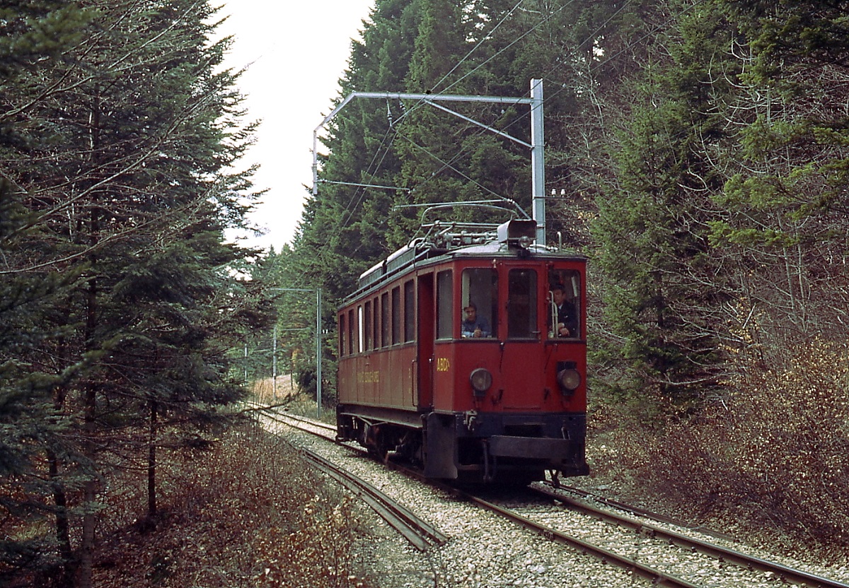 Ein ABDe 4/4 der NStCM ist im Mai 1980 zwischen St. Cergue und Arzier unterwegs. Zur Schonung der nicht nachgespannten Fahrleitung verkehrten die Triebwagen abw�rts mit abgesenktem Stormabnehmer.