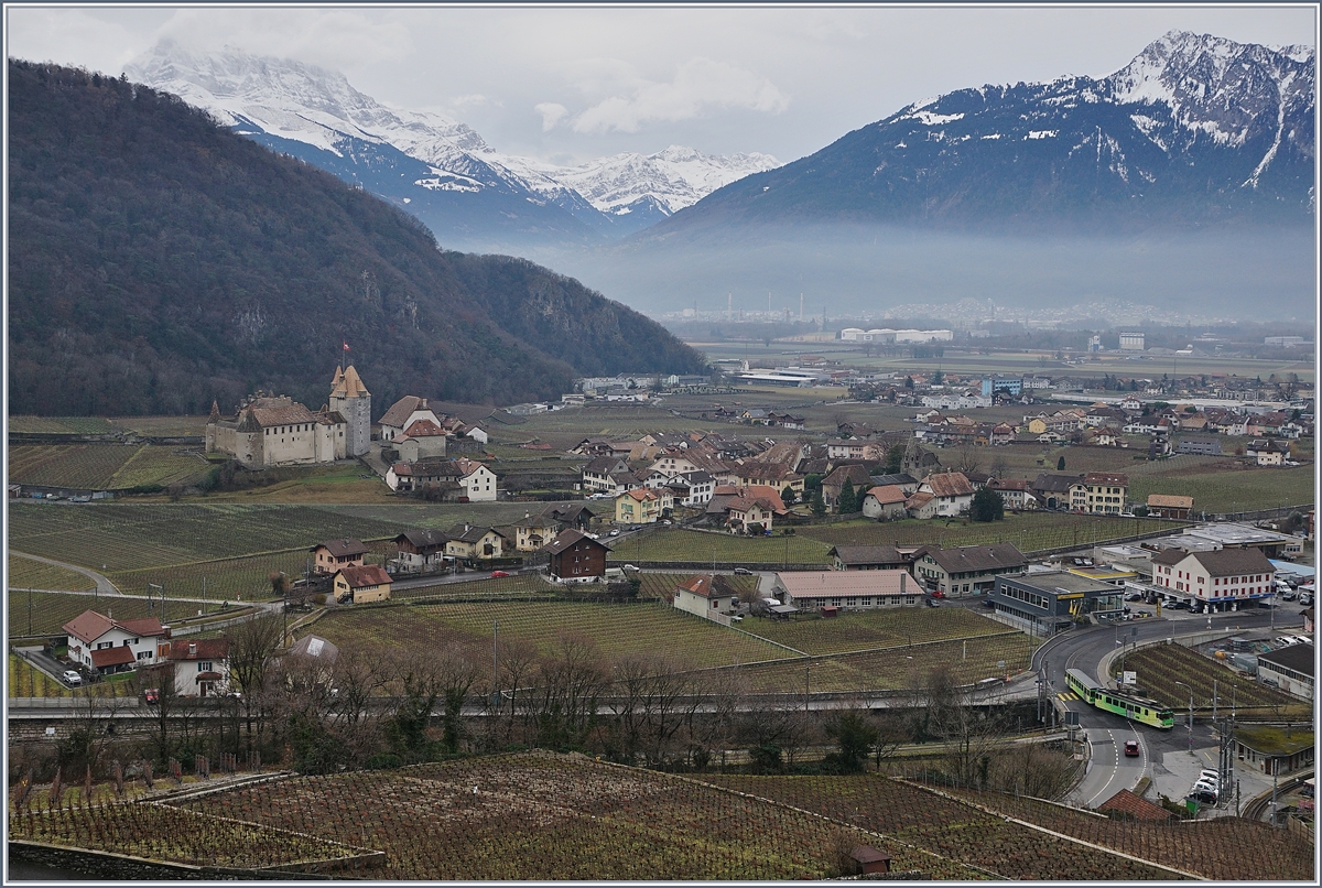 Ein Blick auf Aigle: Rechts unten verl�sst der A-L BDeh 4/4 313 mit seinem Bt 363 auf der Fahrt von Leysin nach Aigle nach der Spitzkehre Aigle D�p�t A-L, rechts im Bild ist das Schloss von Aigle zu sehen und in der Bildmitte, von Wolken verh�llt die Dents de Midi.
7. Jan. 2018