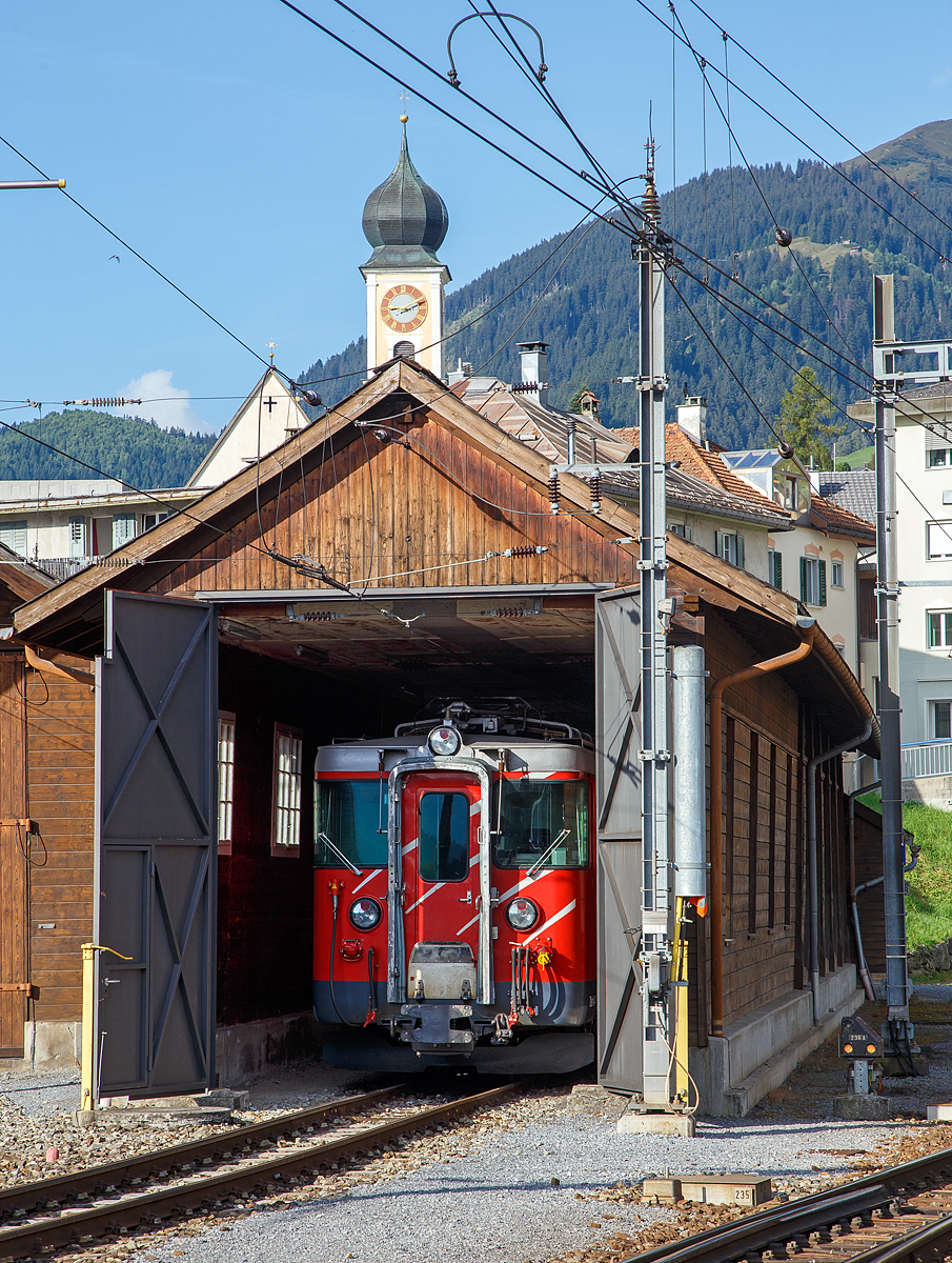 Ein Blick in die Remise der MGB beim Bahnhof Disentis/Mustér am 07.09.2021. Hier steht ein elektrischer Zahnrad-Gepäcktriebwagen MGB Deh 4/4 I, ex FO Deh 4/4 I, welche Fahrzeugnummer (51 bis 55) es ist kann in nicht sagen, da die Nummern an den Fronten nicht angeschrieben werden. Die zusehende Front, wäre im Betrieb, die dem Zug zugewandte Seite.

Diese Gepäcktriebwagen wurden 1972, für die damalige bis zur Fusion (zum 01. Jan. 2003) eigenständigen  Furka-Oberalp-Bahn (FO), gebaut. Der Triebwagenkasten ist von SIG, die Triebdrehgestelle von SLM und die elektrische Ausrüstung von BBC.

