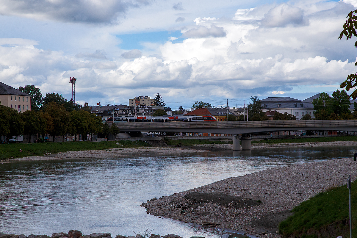 Ein dreiteiliger Elektrotriebzug der ÖBB Reihe 4023 vom Typ Bombardier TALENT (Talbots leichter Nahverkehrs-Triebwagen) vom Salzburger Verkehr überquert am 10.09.2022 in Salzburg die Salzach. Er fährt als S3 der S-Bahn Salzburg die Verbindung Schwarzach – Salzburg - Freilassing – Bad Reichenhall.