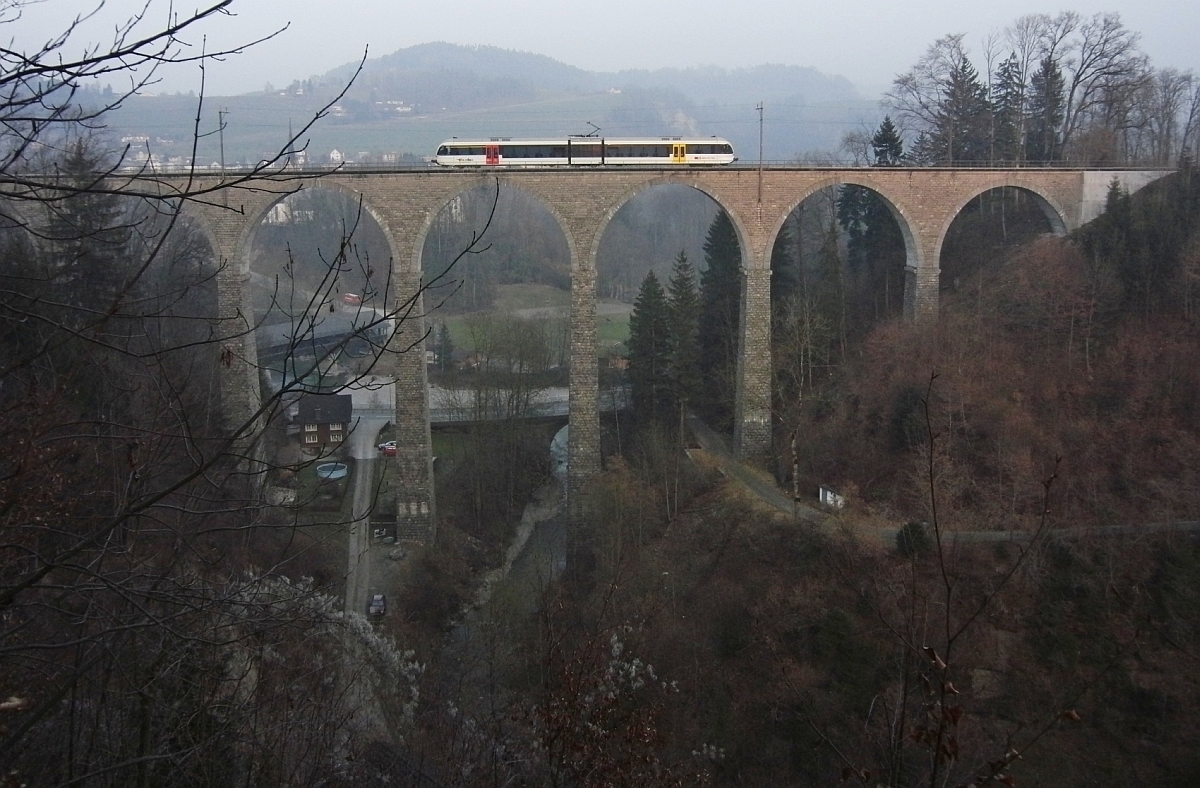 Ein GTW als S9 23970 von Wil nach Nesslau-Neu St. Johann �berquert am 05.03.2011 bei L�tisburg den tief eingeschnittenen Hammertobel auf dem Guggenloch-Viadukt.
Der unter dem Viadukt durchflie�ende Gonzenbach m�ndet kurz dahinter in die Thur.