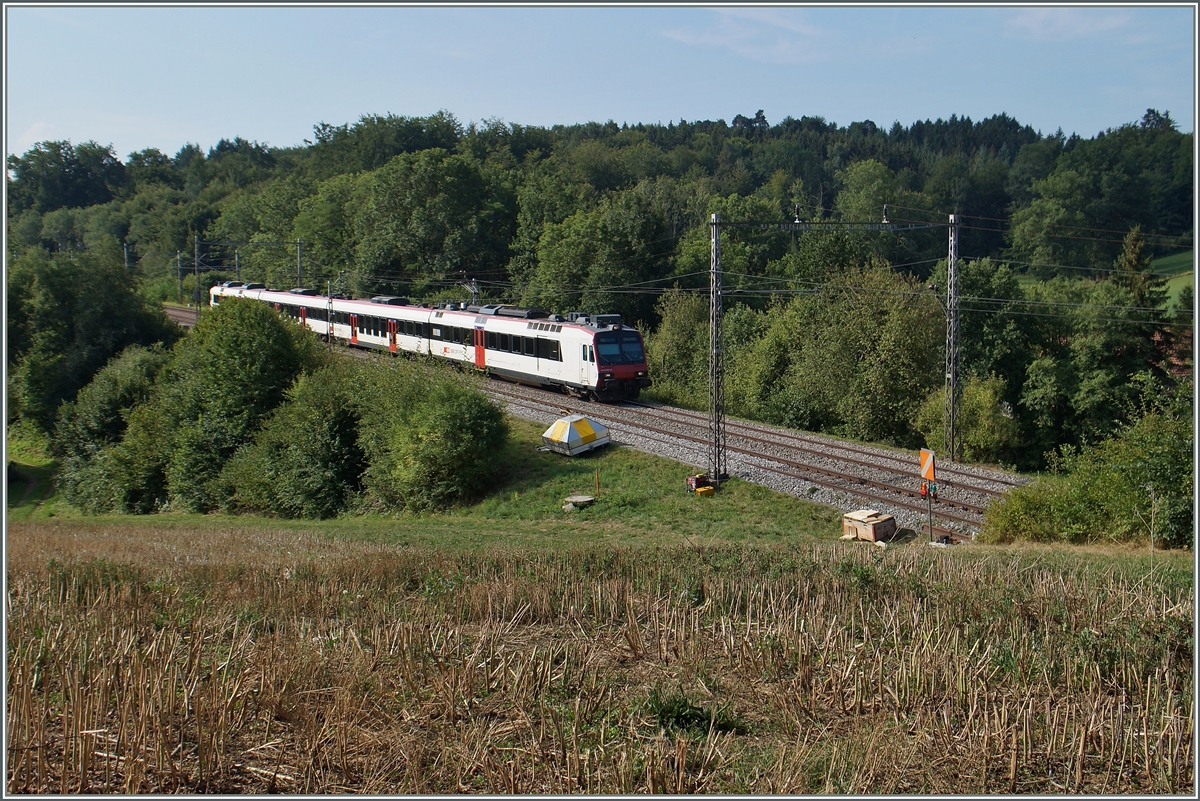 Ein SBB RBDe 560  Domino  als S 40 Romont - Bulle zwischen Neyruz und Rosé unter den wohl letzten alten Fahrleitnungsmasten zwischen St.Gallen und Genève. 
6 .August 2015