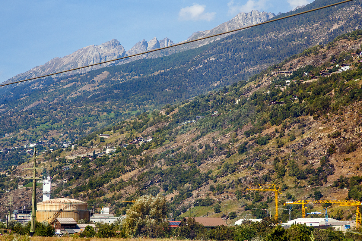 Ein such den Zug Bild....
Ein Blick auf die BLS Lötschberg-Bergstrecke zwei gekuppelte BLS RABe 535  Lötschberger  fahren am 08.09.2021 beim Bahnhof Eggerberg (835 m ü. M.) gerade hinauf. 
Das Bild konnte ich durchs die Fensterscheibe aus dem SBB IC 8 (Brig – Romanshorn), hier kurz vor Visp machen.

Als Lötschberg-Bergstrecke wird die Schweizer Eisenbahnstrecke (Kursbuchfeld 330, vor Eröffnung des Basistunnels 300) bezeichnet, welche das Berner Oberland mit dem Wallis verbindet. Das Herzstück der Strecke ist der 14.612 m lange Lötschbergtunnel. Die Strecke ist aufgrund ihrer Doppelschleife (Kehrtunnel) an der Nordrampe, ihrer vielen Kunstbauten und der Südrampe im Rhonetal unter Eisenbahnenthusiasten weltbekannt. Mit der Eröffnung des Lötschberg-Basistunnels 2007 nimmt dieser nun einen Großteil des Verkehrs zwischen Frutigen und Brig auf. Die Bergstrecke wird seitdem nur noch durch RegioExpress- sowie von Güterzügen befahren, die nicht durch den Basistunnel befahren können.
