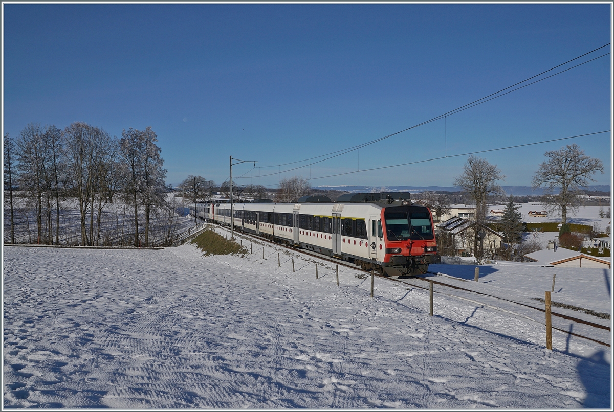 Ein tpf und ein SBB RBDe 560  Domino sind als RE 4016 von Düdingen nach Bulle unterwegs und erreichen in Kürze die Dienst- und Kreuzungsstation Vuisternens-devant- Romont. Weit im Hintergrund ist sogar noch der Jura zu erkennen. 

23. Dezember 2021