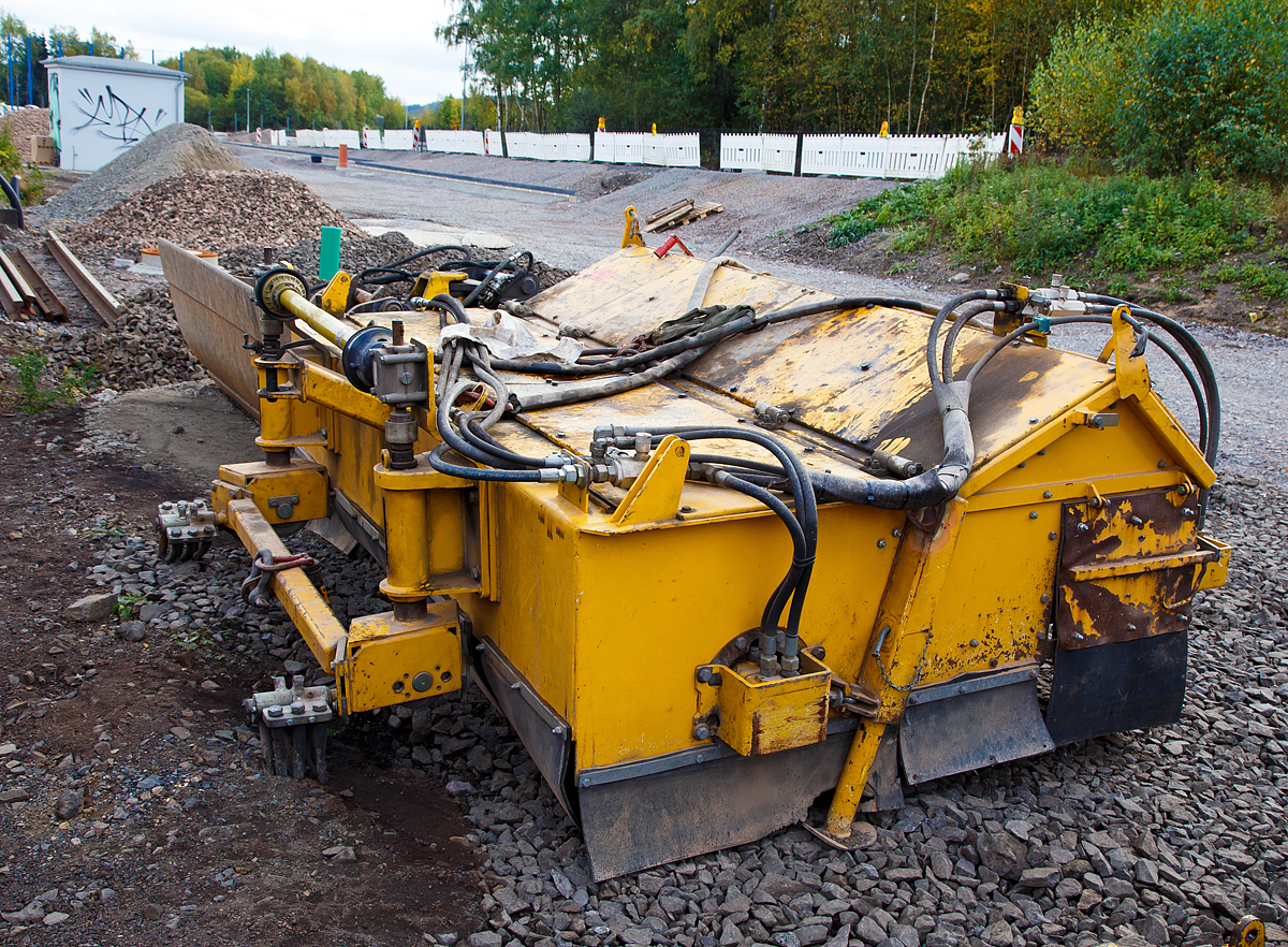
Ein WINDHOFF Schotterbesen ASB abgestellt am 15.10.2016 in Kreuztal. 

Das Gerät wurde 2004 von der WINDHOFF Gleisbautechnik GmbH in Rheine unter der Fabriknummer 101002268 gebaut.

Der WINDHOFF Schotterbesen ASB wird eingesetzt, um überzähligen Schotter aus dem Gleiskörper zu entfernen.

Die hydraulische Energieversorgung erfolgt vom 2-Wege- Bagger oder der Gleisbaumaschine aus.

Die Anlenkung des Besens an einen Bagger erfolgt durch eine Kuppelstange. Das Gerät fährt auf 4 Schienenrollen. Für die Verladung kann ein 4-Punkt Kettengehänge eingesetzt werden.