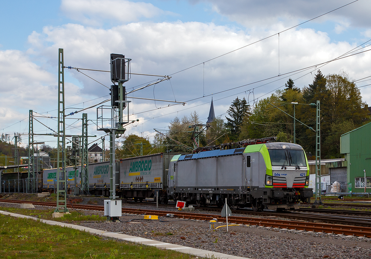 Eine der 25 neuen von der BLS Cargo in der 2. Serie bestellten Re 475 (Siemens Vectron MS)....
Die recht neue BLS Cargo 418 – Re 475 421-4 (91 85 4475 421-4 CH-BLSC) f�hrt am 07.05.2021 mit einem KLV-Zug durch den Bahnhof Betzdorf (Sieg) in Richtung K�ln.

Die Siemens Vectron MS wurden 2020 von Siemens Mobilitiy in M�nchen-Allach unter der Fabriknummer 22867 gebaut, sie hat die Zulassungen f�r CH/ D/ A/ I / NL/B und kann so vom Mittelmeer bis an die Nordsee ohne Lokwechsel durchfahren. Die BLS Re 475 der zweiten Serie 475 416 – 475 440 (es sind noch nicht alle ausgeliefert) haben zus�tzlich die Zulassung f�r Belgien (B). Sie haben eine H�chstgeschwindigkeit von 200 km/h und eine Leistung von 6.400 kW.

Nach Abschluss der Lieferungen der 2. Serie hat die BLS Cargo dann insgesamt 40 Loks der Baureihe Re 475 (Siemens Vectron MS). Der kleine Unterschied zwischen der beiden Serien ist nur das die Lok der 2. Serie auch durch Belgien 