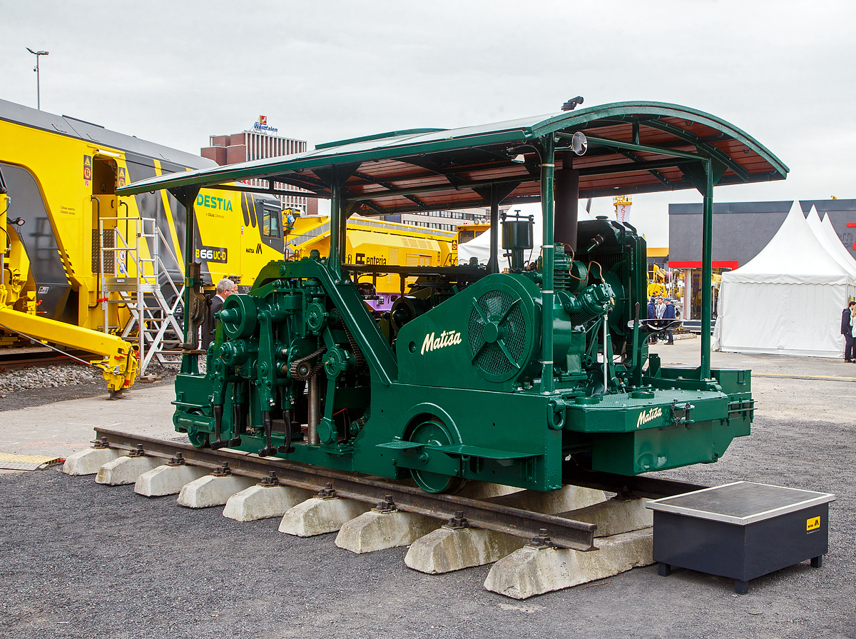 Eine historische Matisa Stopfmaschine, die 1te Standard Stopfmaschine auf dem Markt, ausgestellt auf der iaf 2022 in Münster (hier am 31.05.2022). Diese Stopfmaschine wurden zwischen 1945 und 1954, in den Spurweiten 900 mm bis 1.676 mm von Matisa als Standardmaschinen produziert. Diese in Normalspurausführung (1.435 mm) wurde von Matisa von 2021 bis 2022 restauriert. 

Es ist schon ein gewaltiger Unterschied, wenn man sie mit modernen Maschinen vergleicht. Aber diese Maschine leistete nun die Arbeit, die bis zu diesem Zeitpunkt durch sehr harte Arbeit von 20 bis 30 Männern mit Spitzhacken und Schaufeln geleistet wurde. Und durch die Maschine hatte sich die Verdichtungsqualität deutlich erhöht. 

TECHNISCHE DATEN:
Spurweite: 1.435 mm, Ausführung von 900 mm bis 1676 mm möglich
Achsanzahl: 2
Achsformel: A´1´
Länge: 4.600 mm
Breite: 2.600 mm
Höchstgeschwindigkeit: 40 km/h
Motorleistung: 80 PS
Motor: wasser- oder luftgekühlter Diesel- oder Petroleummotor
Arbeitsleistung: bis zu 200 m/h