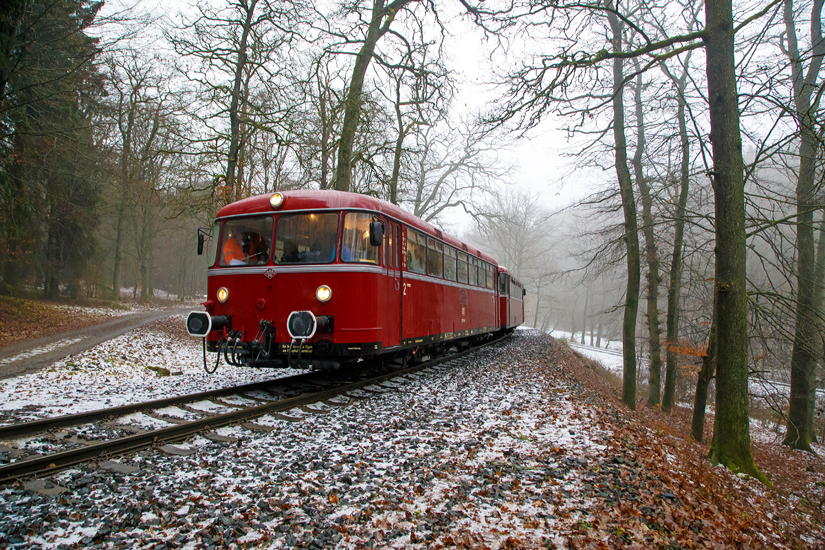 
Eine Schienenbusgarnitur der VEB Vulkan-Eifel-Bahn Betriebsgesellschaft mbH auf Sonderfahrt (bestehend aus 798 670-6, 998 863-5 und 796 784-7) fährt am 26.01.2019 zwischen der ehem. Grube Pfannenberger Einigkeit  (heute Sitz der Schäfer Werke) der Spitzkehre Pfannenberg. 

Die Garnitur befährt die priv. Strecke der Kreisbahn Siegen-Wittgenstein (Betriebsstätte Freien Grunder Eisenbahn - NE 447). Heute gibt es zwischen Herdorf und der Grube Pfannenberger Einigkeit noch jeden Werktag Güterverkehr, obwohl die Erzgrube Pfannenberger Einigkeit ihren Betrieb im April 1962 aufgegeben hat. An ihrer Stelle benötigen seitdem die Schäfer Werke KG den Anschluss für die Zulieferung von Stahl Coils sowohl als Rohstoff als auch für ihren Handel mit deren Zuschnitten nach Kundenwunsch.